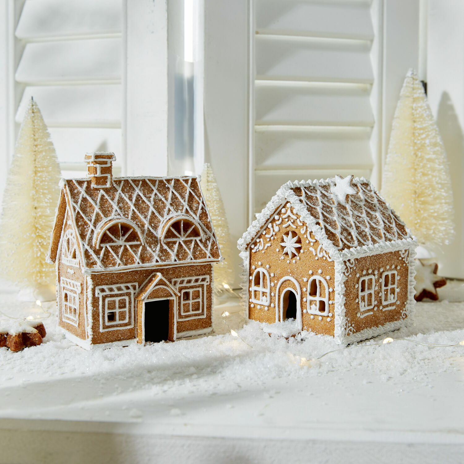 Lot de 2 maisons décoratives Tarreau Deux maisons en pain d'épices décorées de glaçage blanc sur une table de Noël hivernale