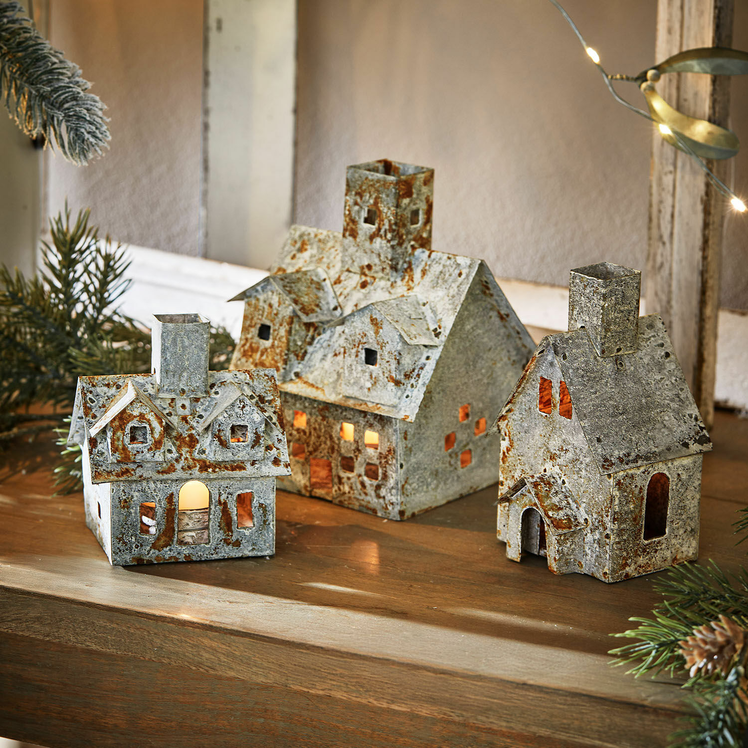 Photophore Granstad Ensemble de trois maisons décoratives en métal rouillé avec éclairage intérieur sur une table en bois