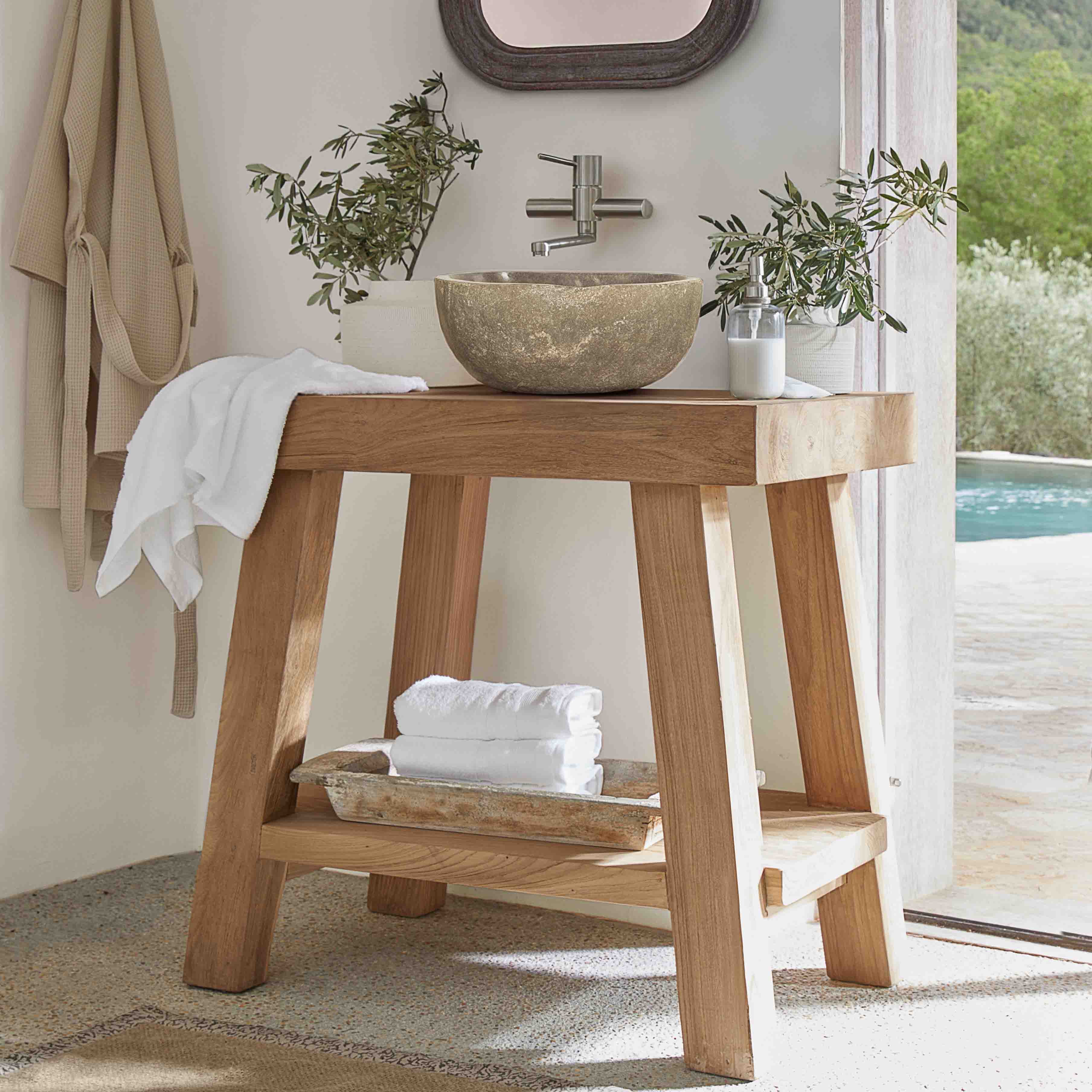 Console de salle de bain en bois avec vasque en pierre et serviettes blanches dans un intérieur lumineux