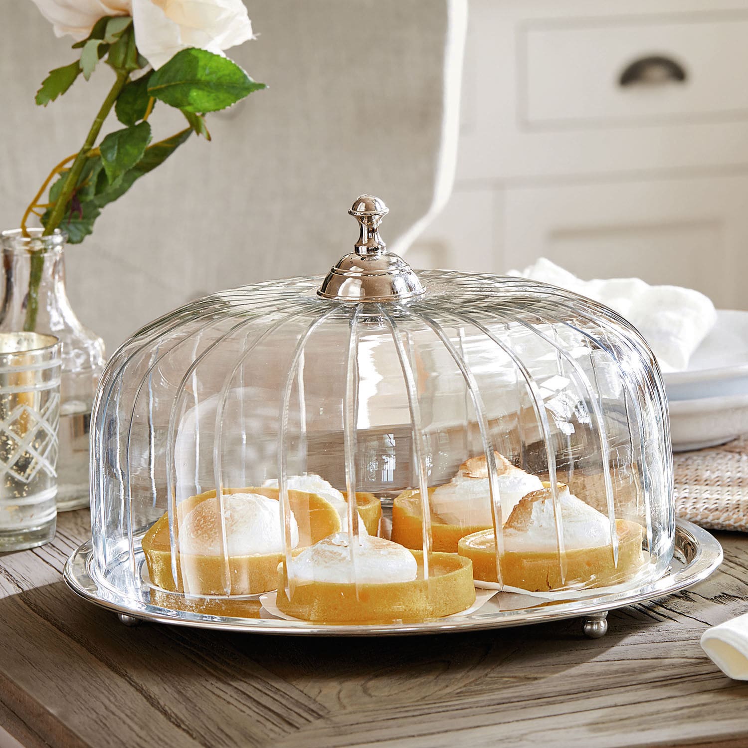 Cloche à gâteau Allaire Cloche en verre avec poignée en métal sur table en bois avec tartes au citron à l'intérieur