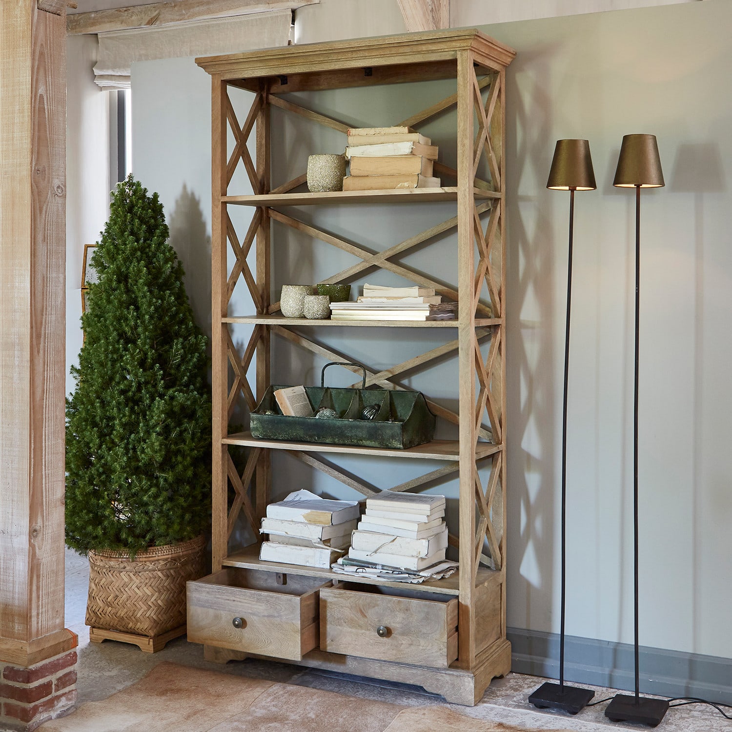 Étagère Vélu Étagère en bois naturel avec tiroirs, livres et décorations dans un salon lumineux