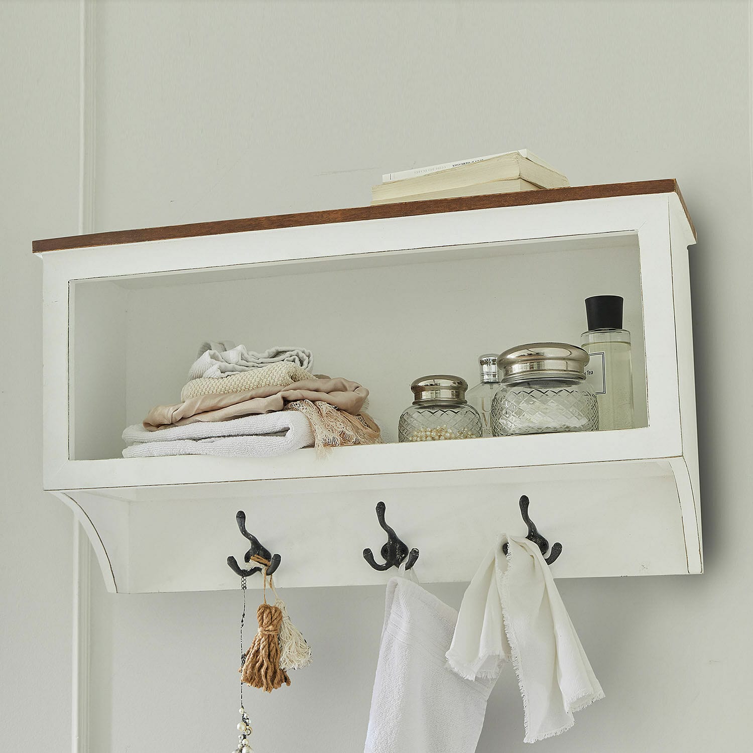 Étagère murale blanche en bois avec crochets, serviettes et bocaux en verre pour salle de bain