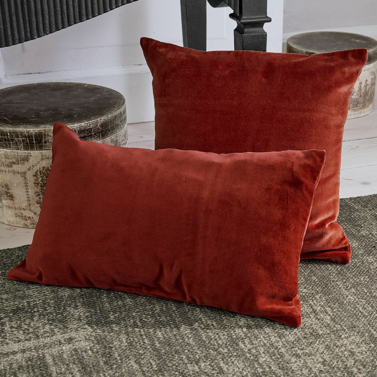 Lot de 2 housses de coussins Tavoliera Ensemble de deux coussins décoratifs rouges en tissu doux posés sur un tapis gris