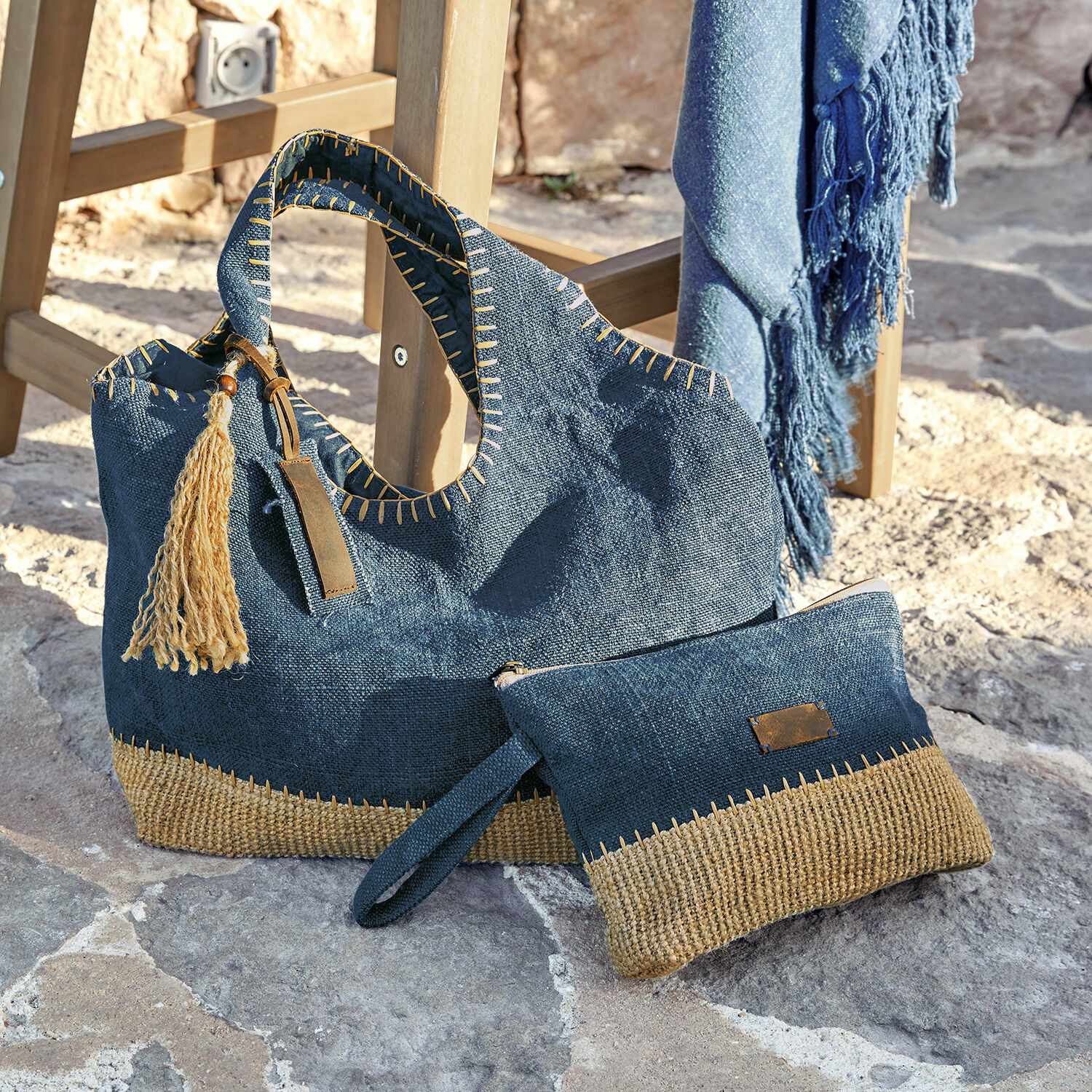 Ensemble cabas et pochette Cacula Sac et pochette bleu marine en tissu naturel avec détails beige posés sur sol en pierre