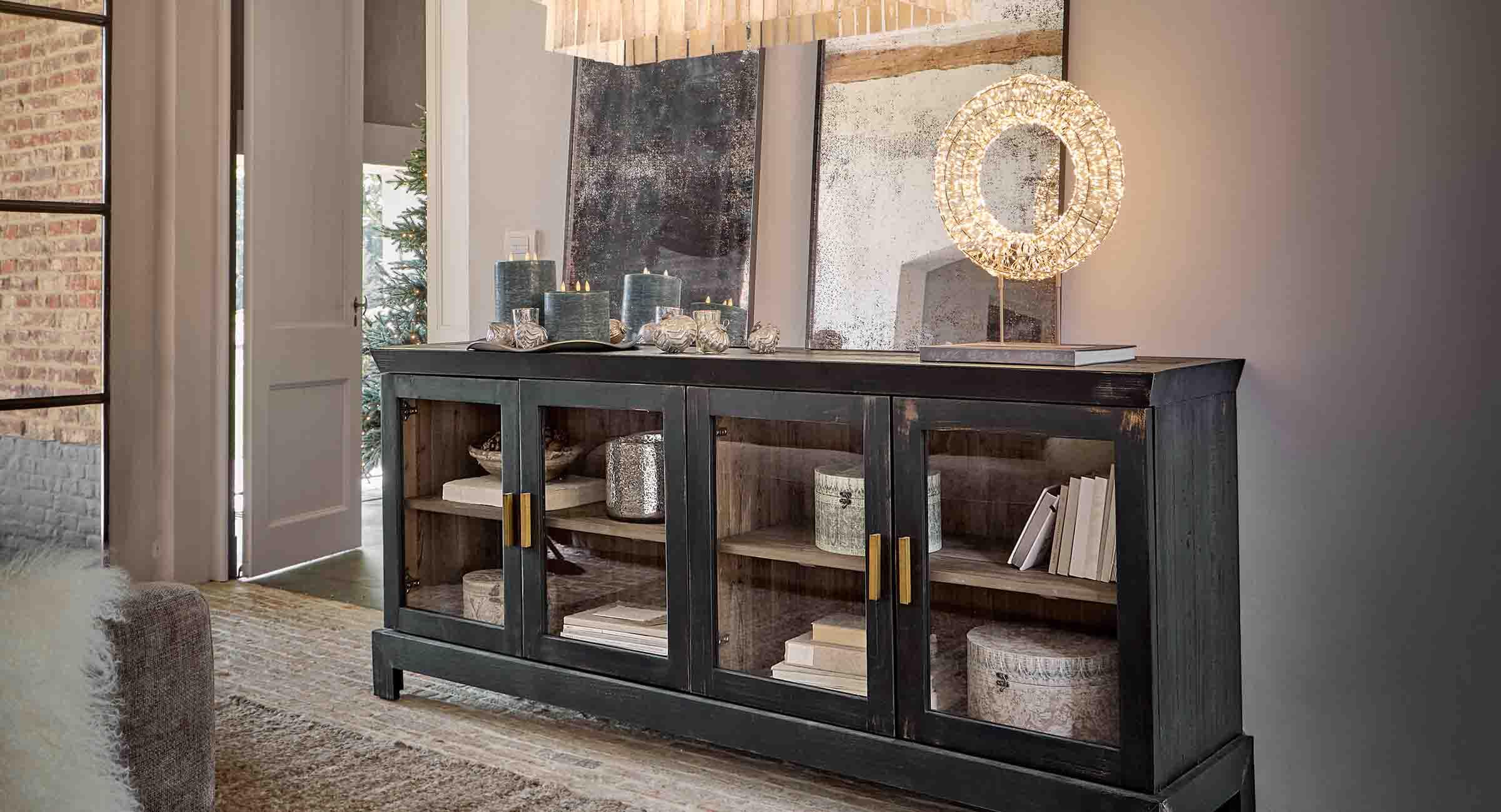 Buffet en bois noir avec portes vitrées et bougies décoratives dans un salon élégant