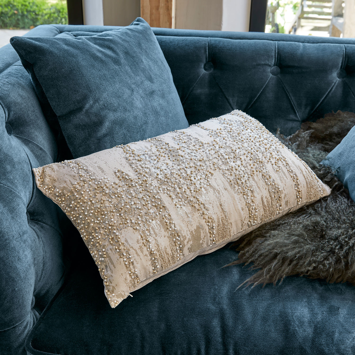 Housse de coussin Aparan Coussin décoratif beige avec perles sur canapé en velours bleu, accessoire élégant pour salon