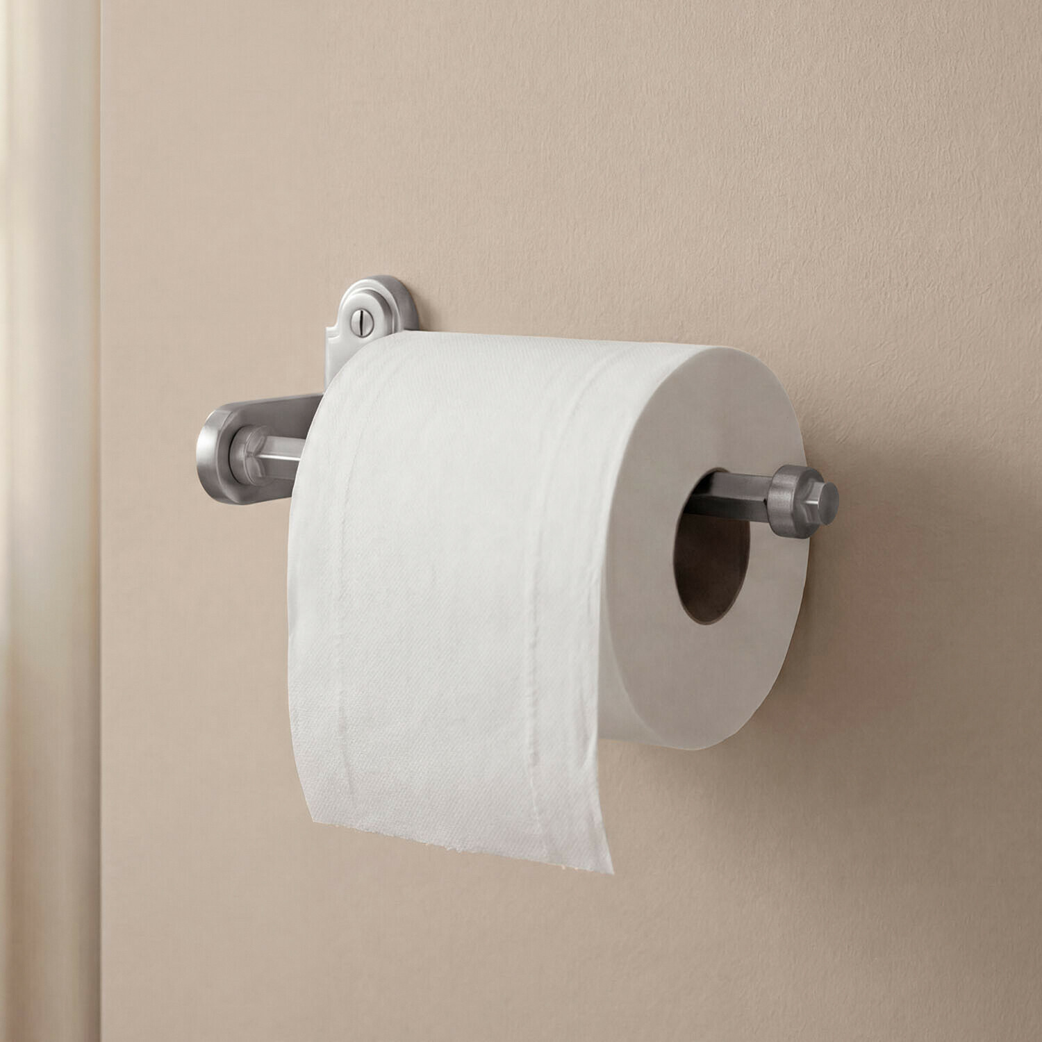 Porte-papier toilette Virellane Porte-papier toilette en métal argenté fixé sur un mur beige dans une salle de bain