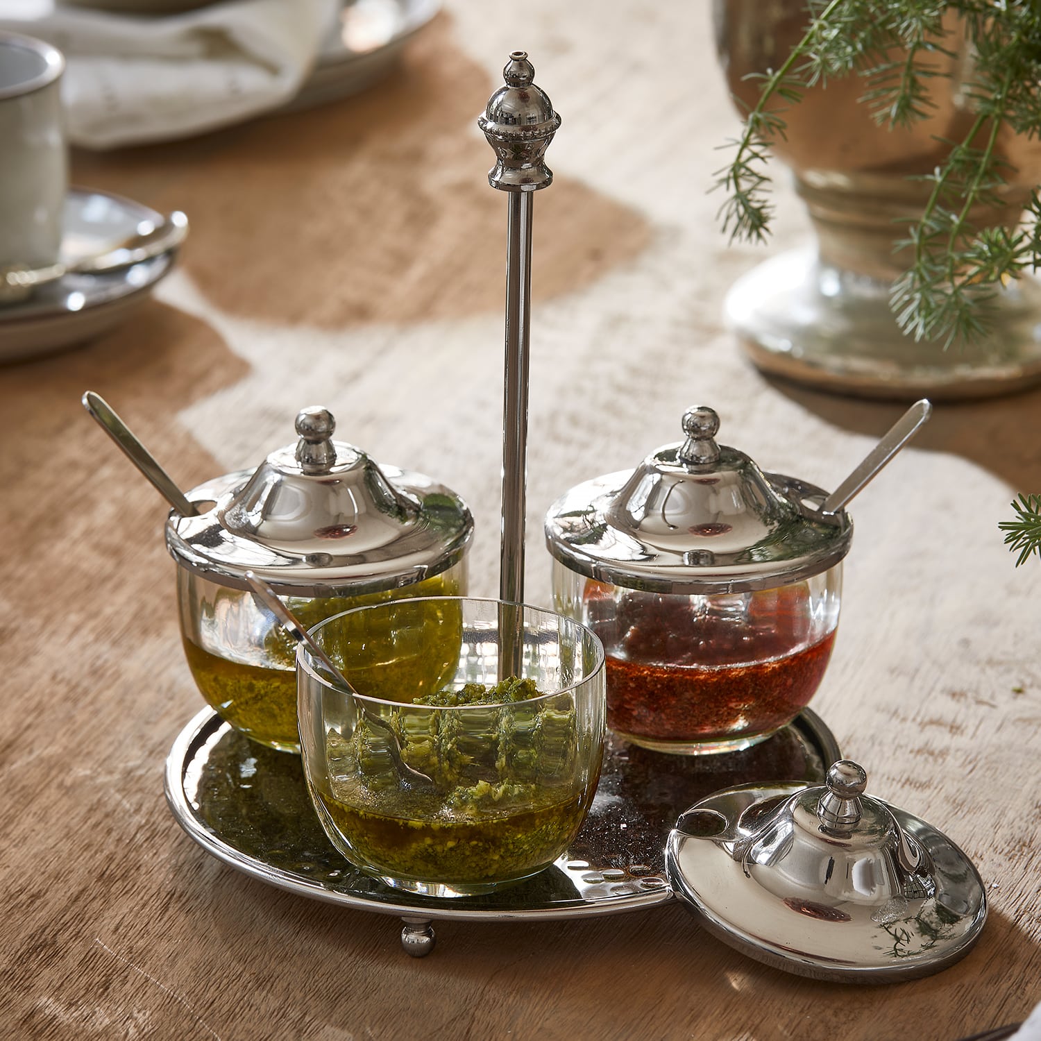 Ensemble de pots à épices en verre avec couvercles métalliques sur plateau en métal sur table en bois
