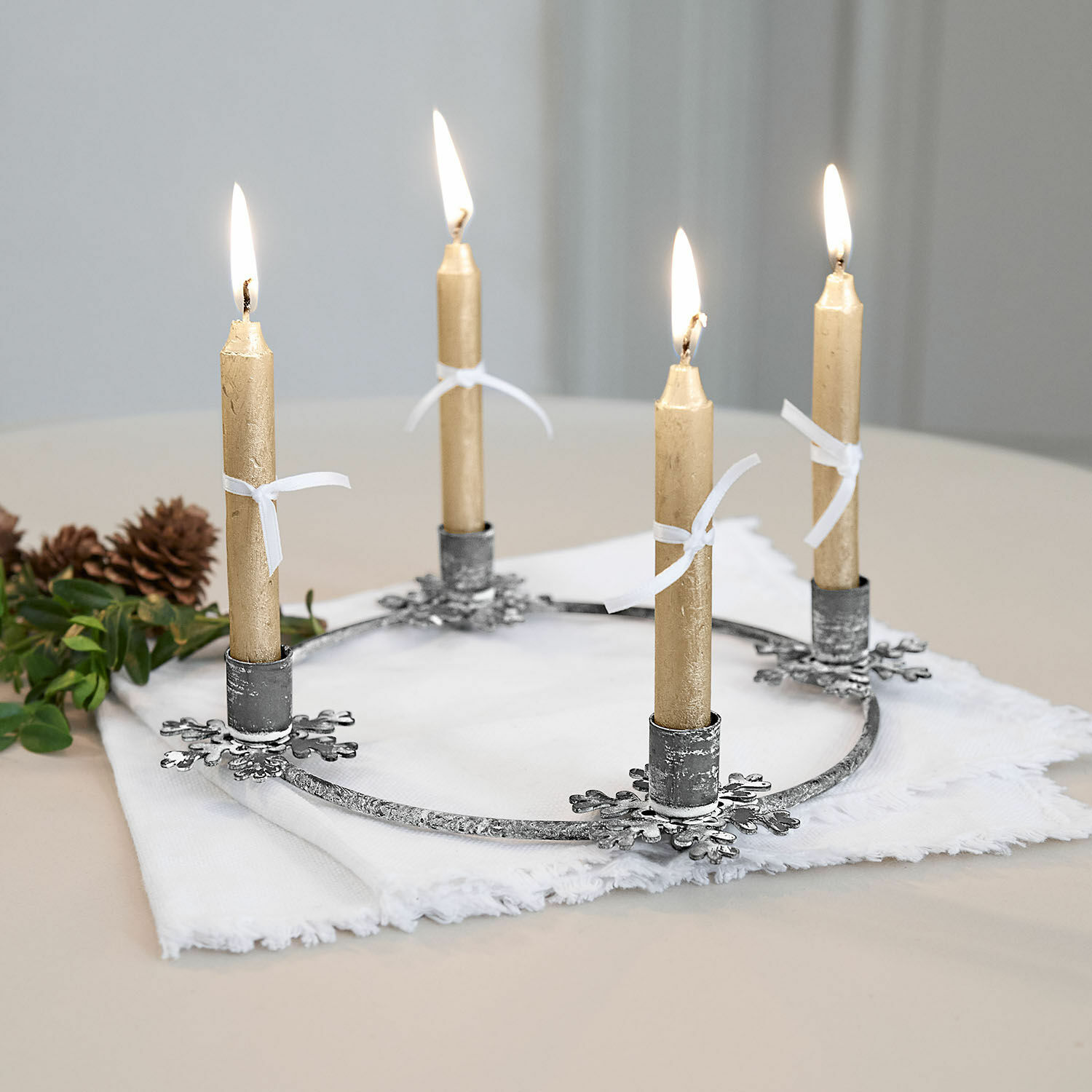 Bougeoir Zarim Couronne de l'Avent en métal avec quatre bougies dorées sur tissu blanc, décoration de Noël