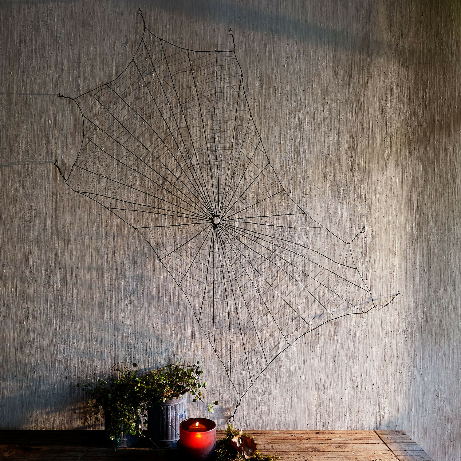 Toile d’araignée décorative Vexilnor Décoration murale toile d'araignée en métal noir avec bougie rouge et plante sur table en bois