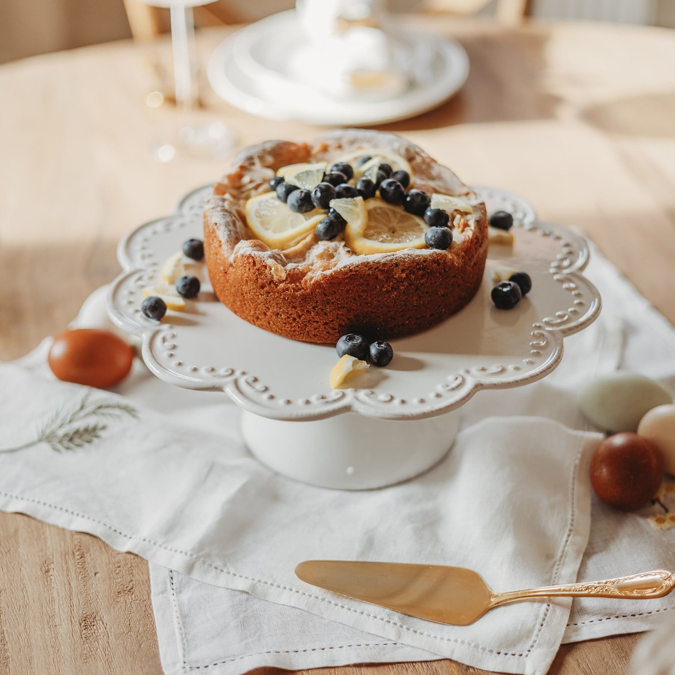 Gâteau aux tranches de citron et myrtilles sur un plat en céramique blanche sur une table en bois