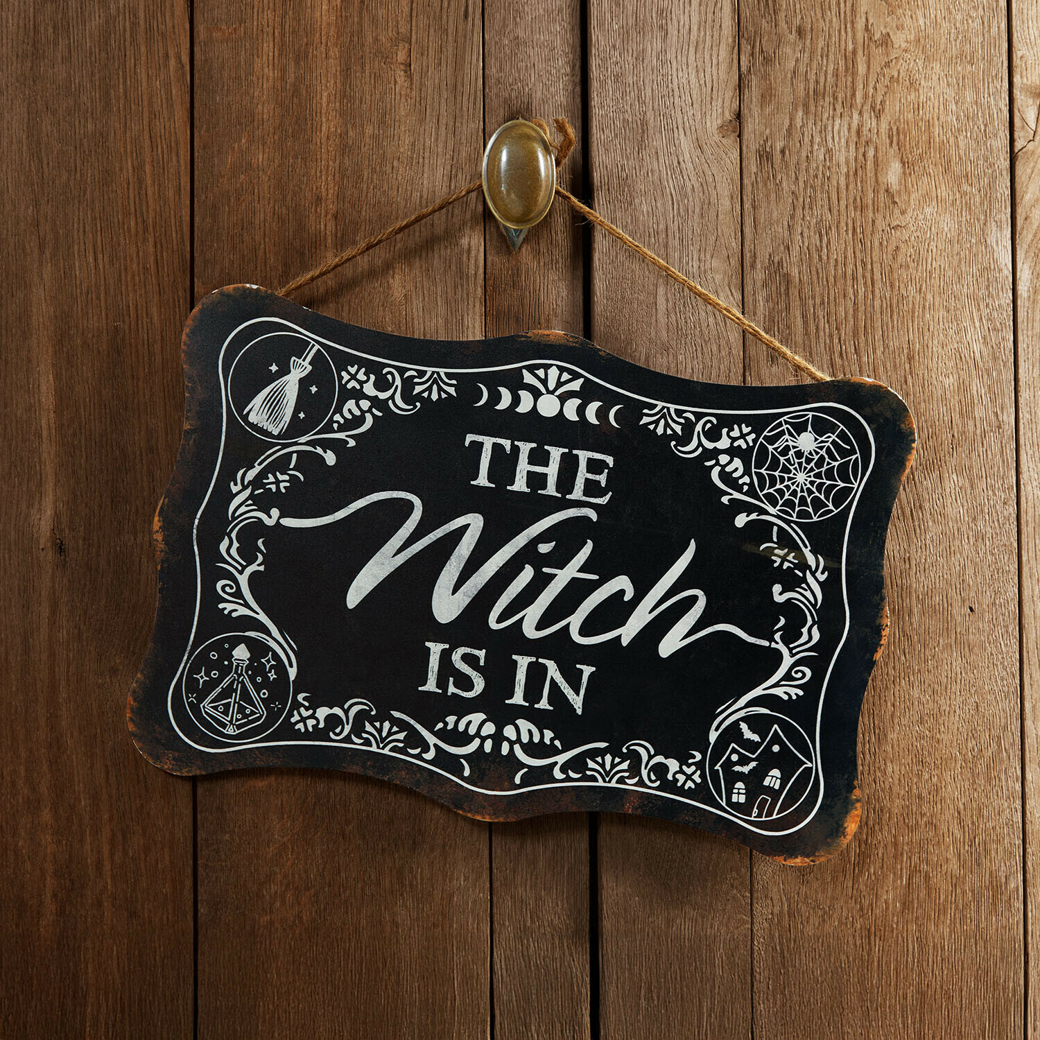 Plaque décorative Talmora Plaque en bois noire avec inscription The Witch is in et décorations blanches sur fond de bois