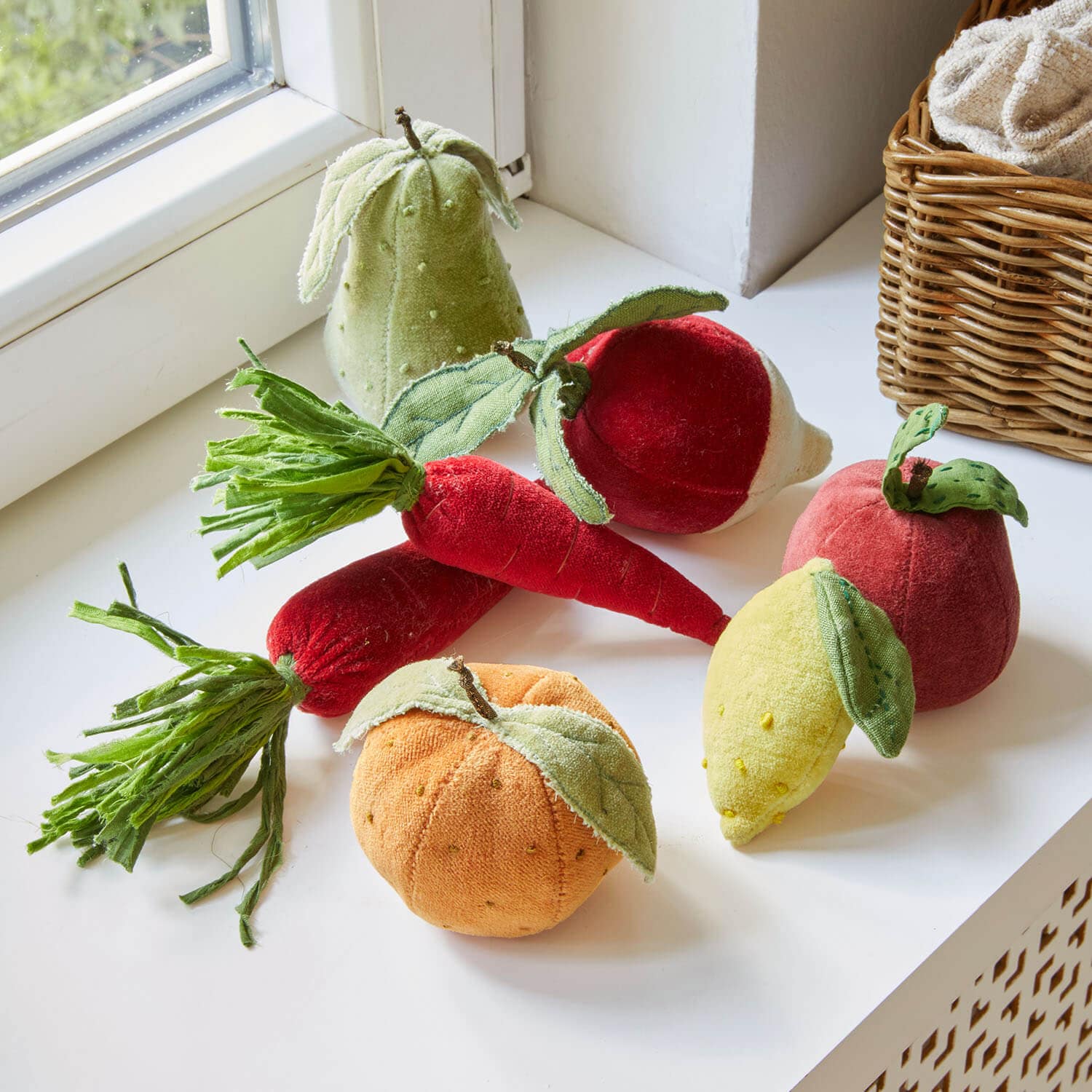 Ensemble de fruits et légumes en tissu coloré sur un rebord de fenêtre blanc, décoration intérieure
