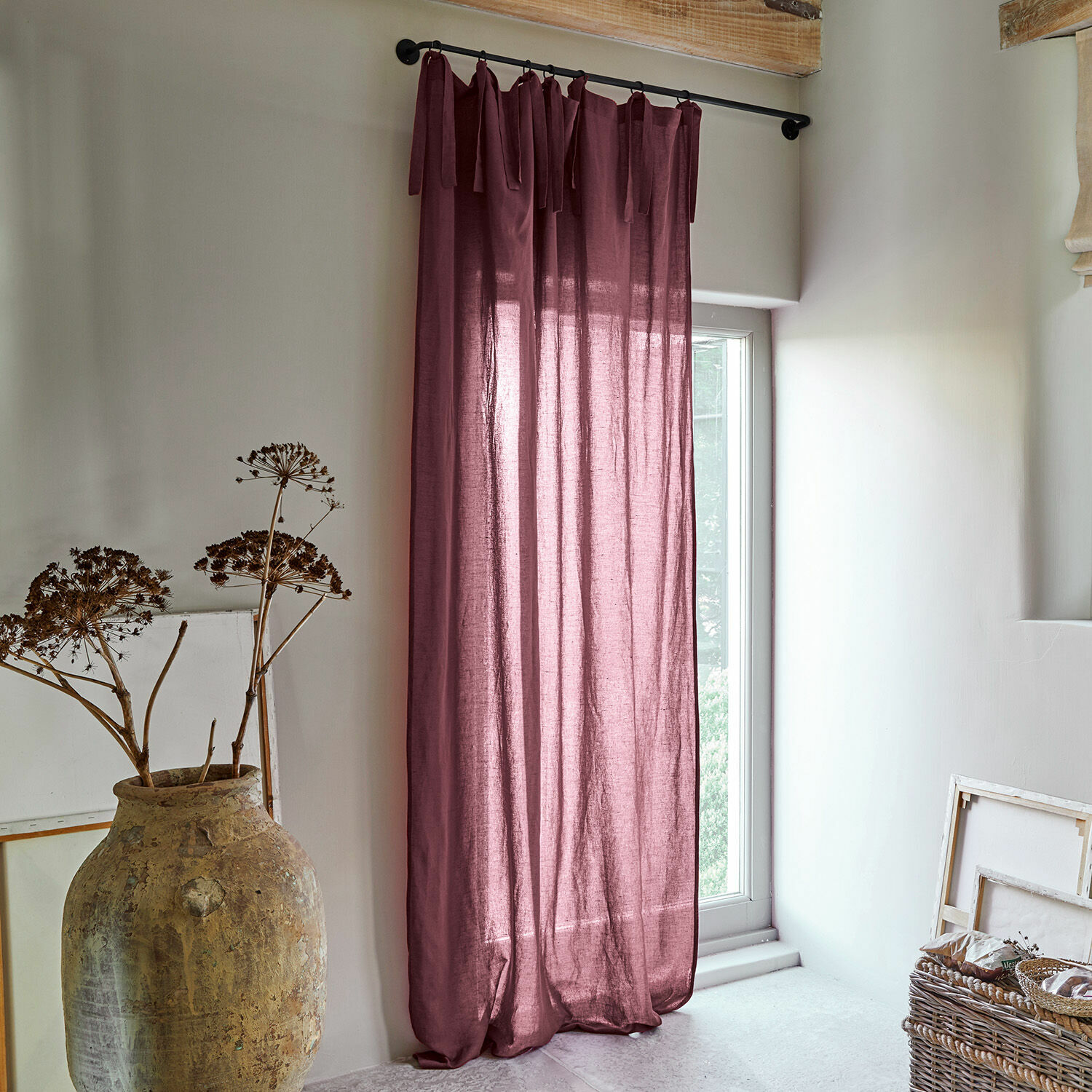Rideau Adara Rideau violet en lin suspendu sur une tringle noire dans un intérieur clair et naturel avec décoration