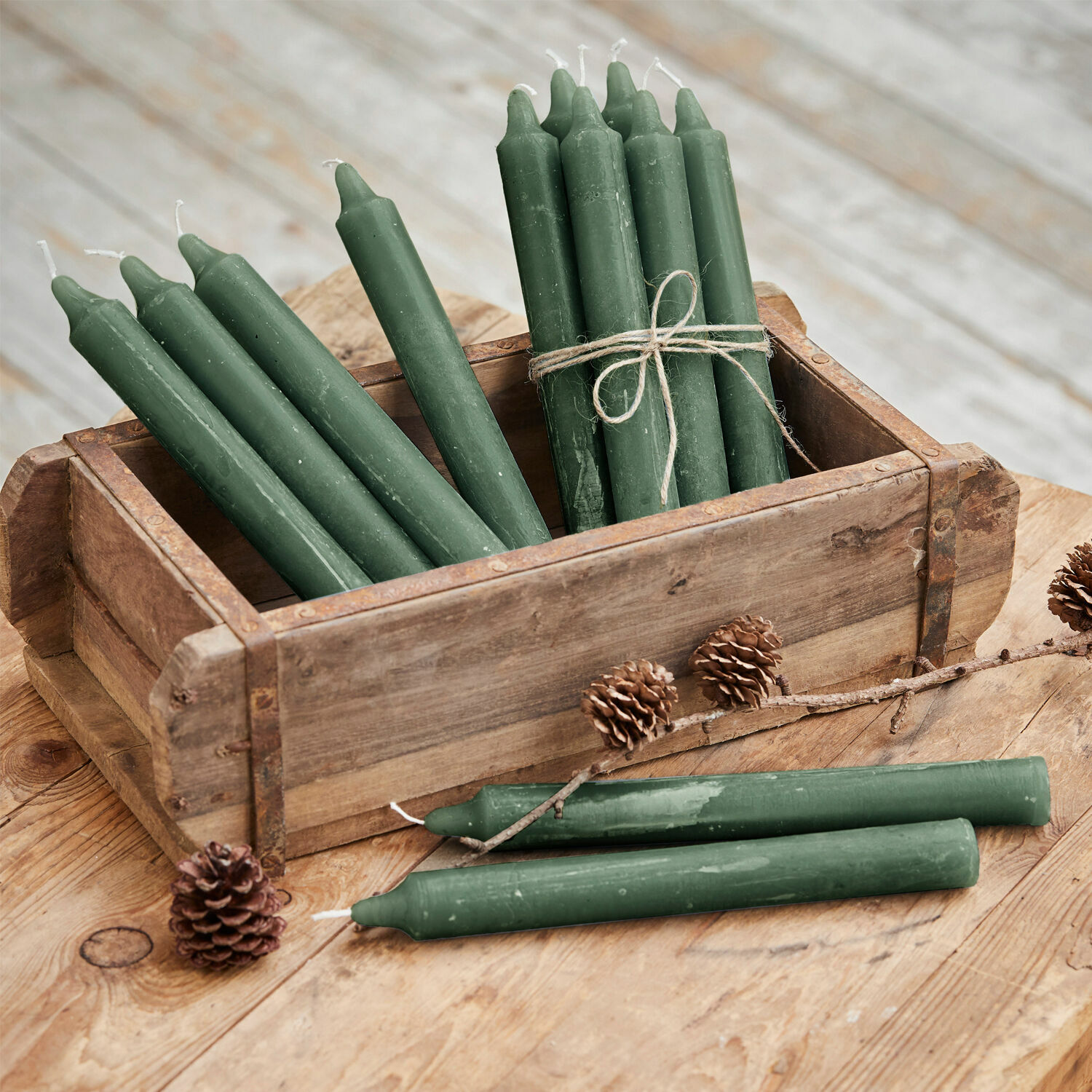 Lot de 12 bougies Bauceau Lot de bougies vertes en cire dans une boîte en bois sur une table rustique en bois