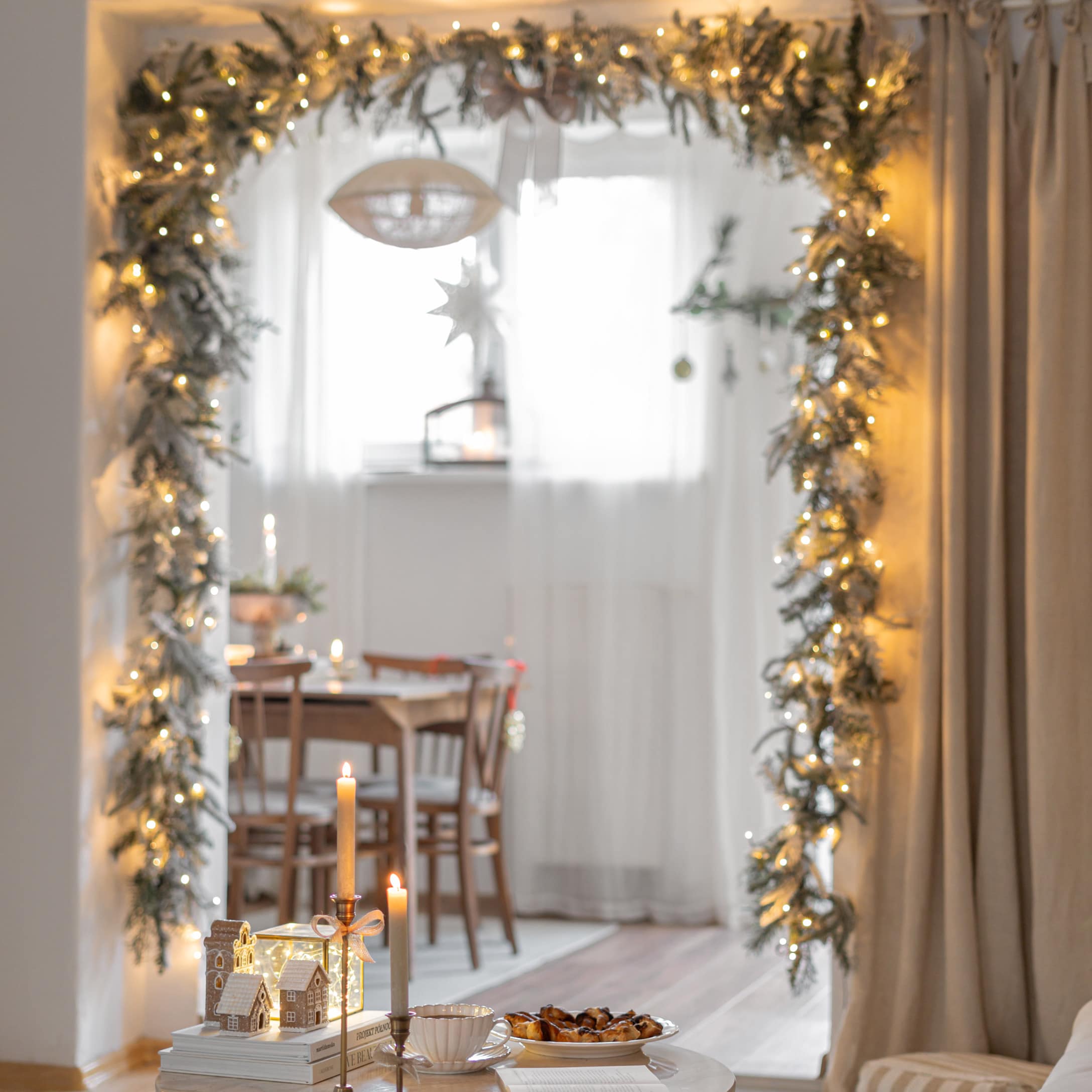 Décoration de Noël avec guirlande lumineuse et bougies dans un intérieur chaleureux avec table en bois