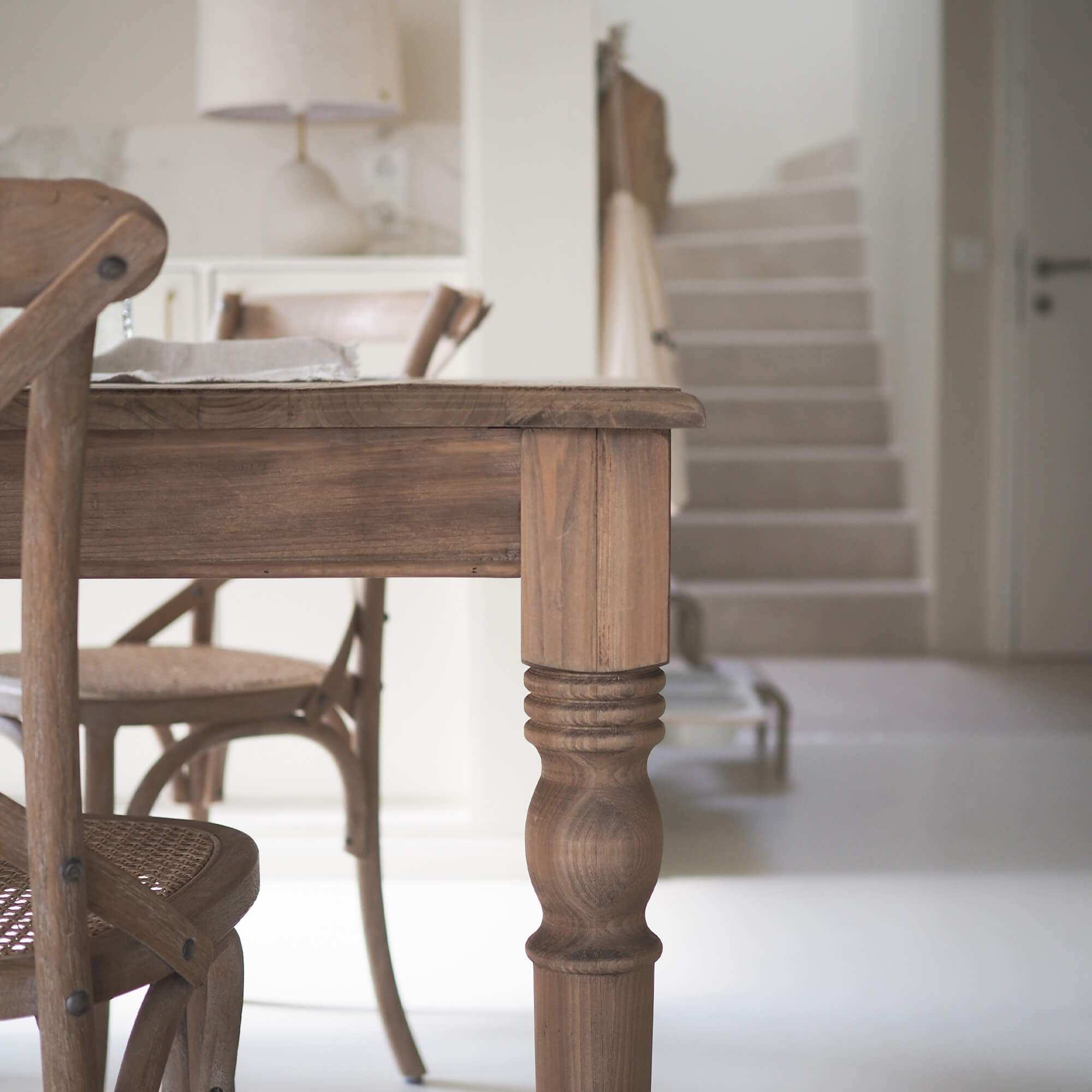 Table et chaises en bois naturel dans un intérieur clair et moderne avec sol blanc