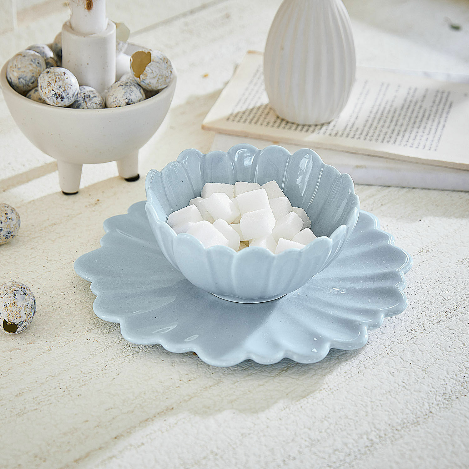 Assiette et bol Tichborne Bol et assiette en céramique bleue avec bord ondulé contenant des cubes de sucre sur une table claire