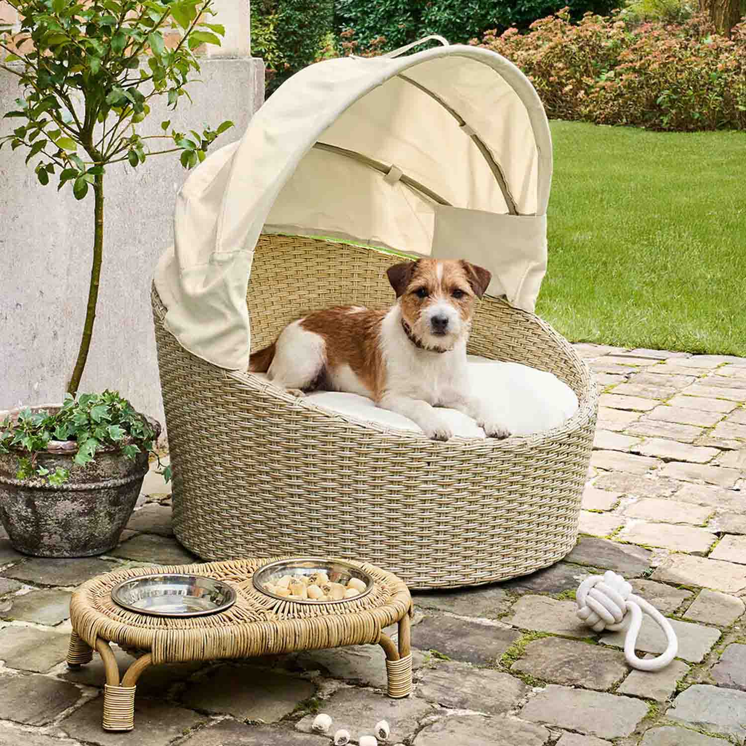 Panier rond pour chien en rotin beige avec coussin crème et auvent, idéal pour extérieur