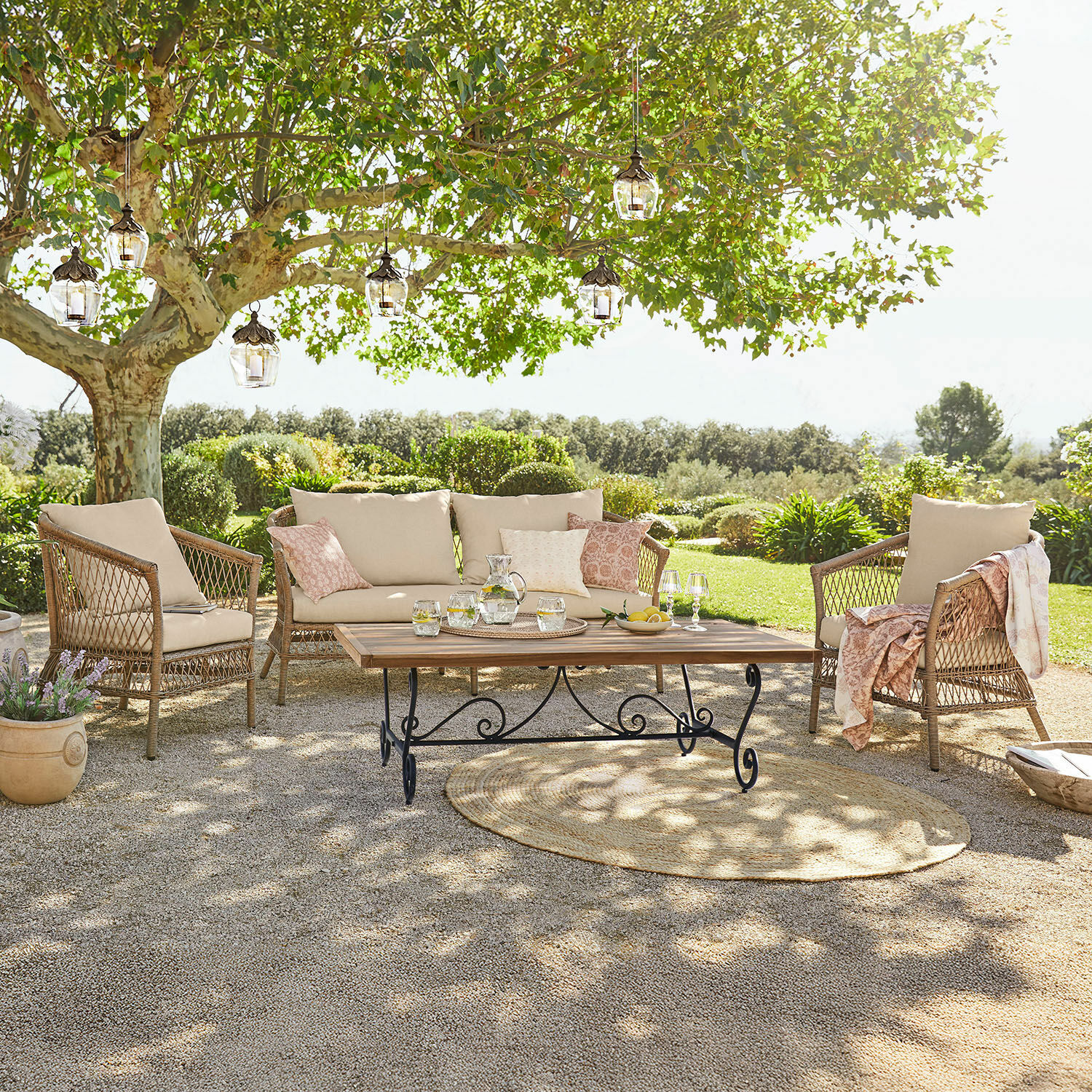 Salon de jardin Farington Ensemble de mobilier de jardin en rotin avec coussins beige et table en bois sur terrasse ensoleillée