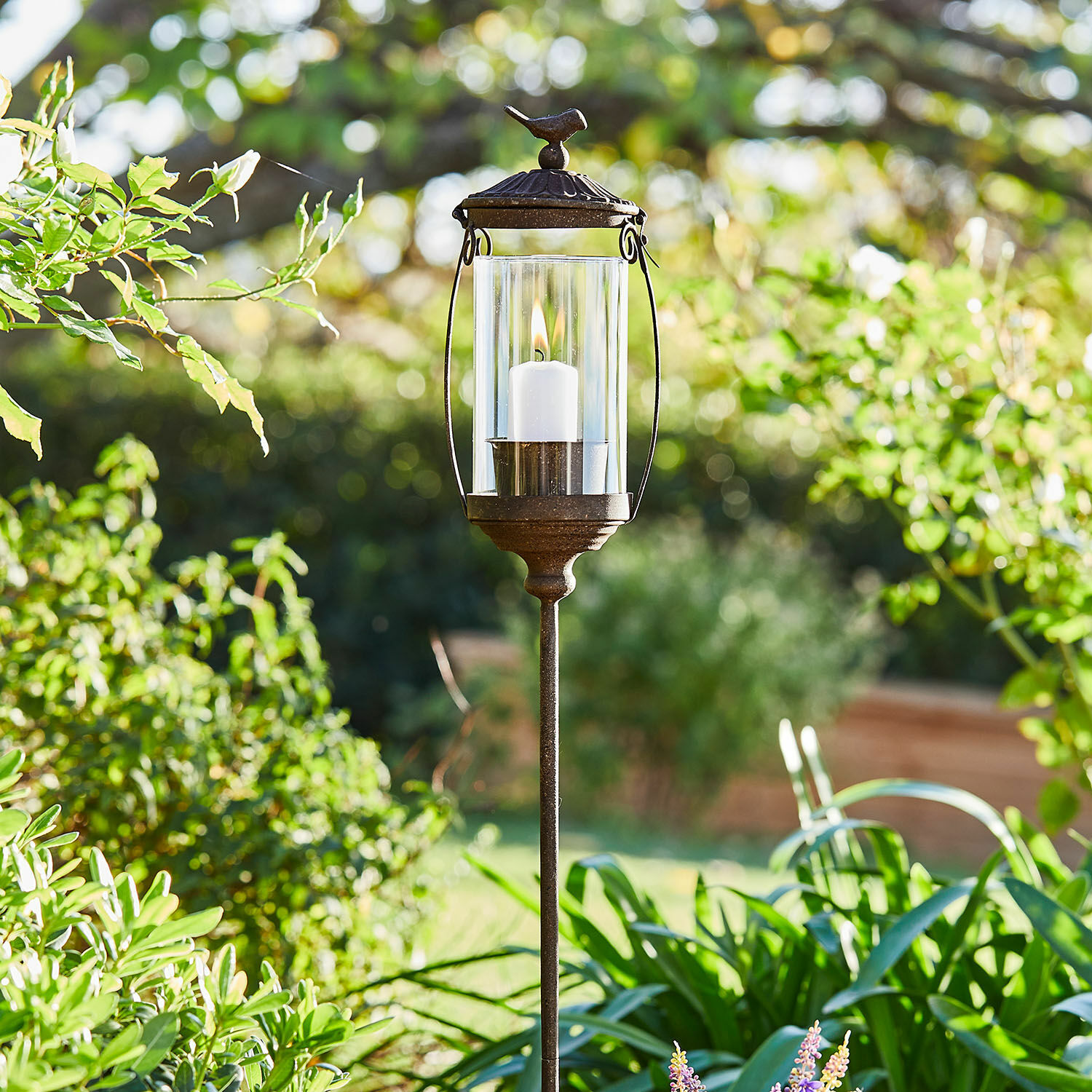 Lanterne Nexoril Lanterne de jardin en métal avec bougie blanche et verre transparent dans un cadre verdoyant
