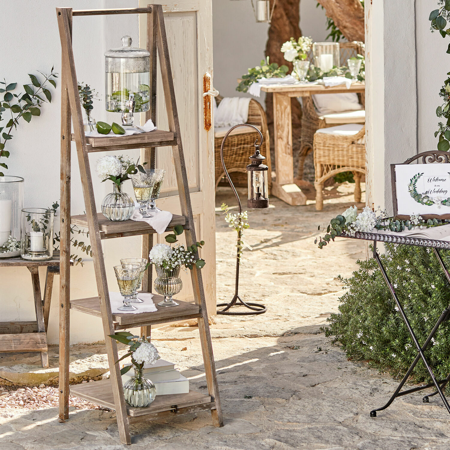 Étagère Lester Échelle en bois avec étagères décorées de vases en verre sur une terrasse en pierre au style rustique