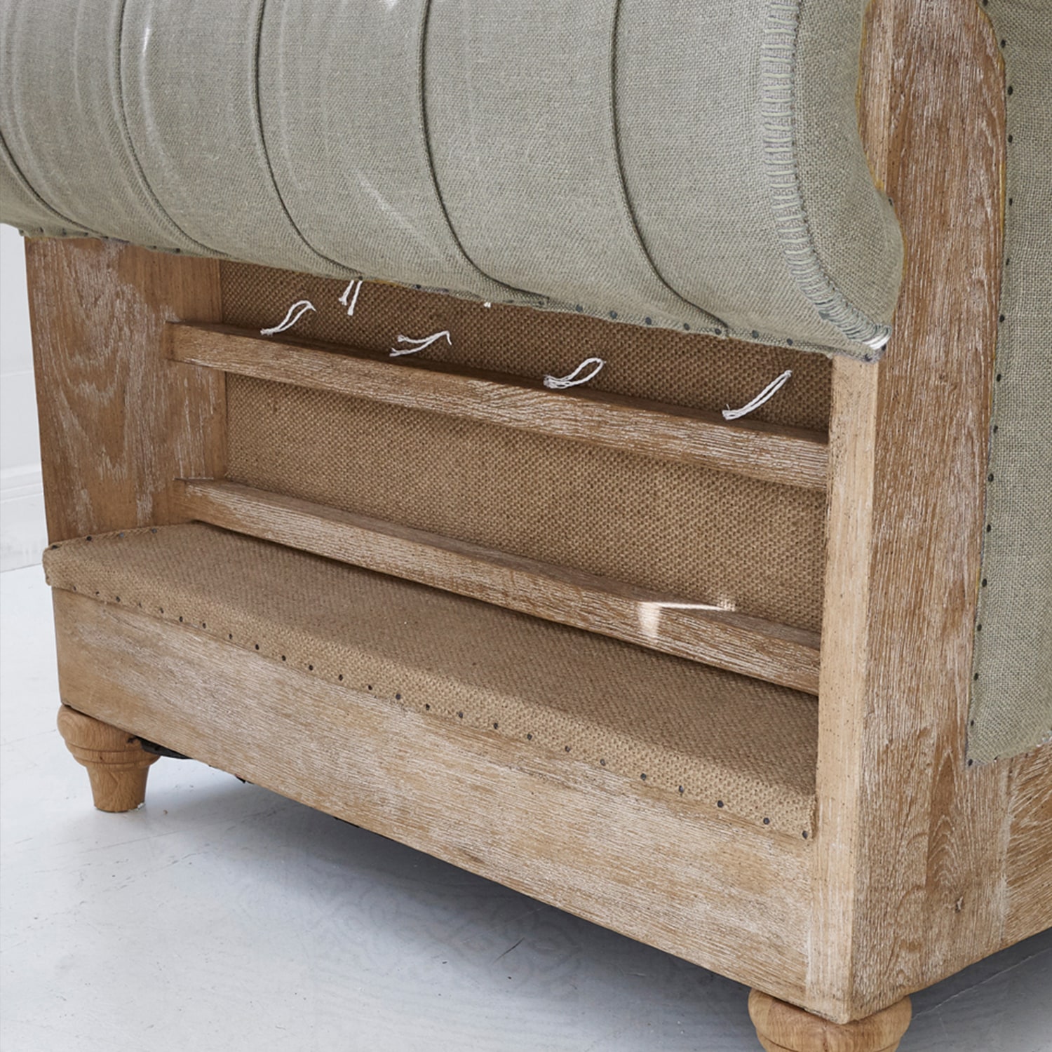 Canapé en bois clair et tissu beige avec structure apparente et détails de finition visibles