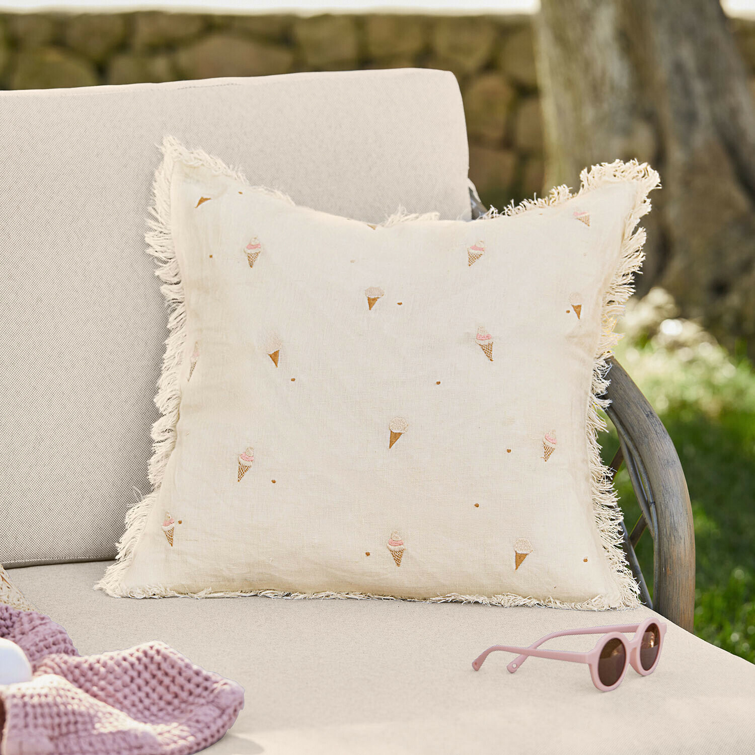 Housse de coussin Toffelis Coussin beige en lin avec franges et motifs de cornets de glace sur canapé clair en extérieur