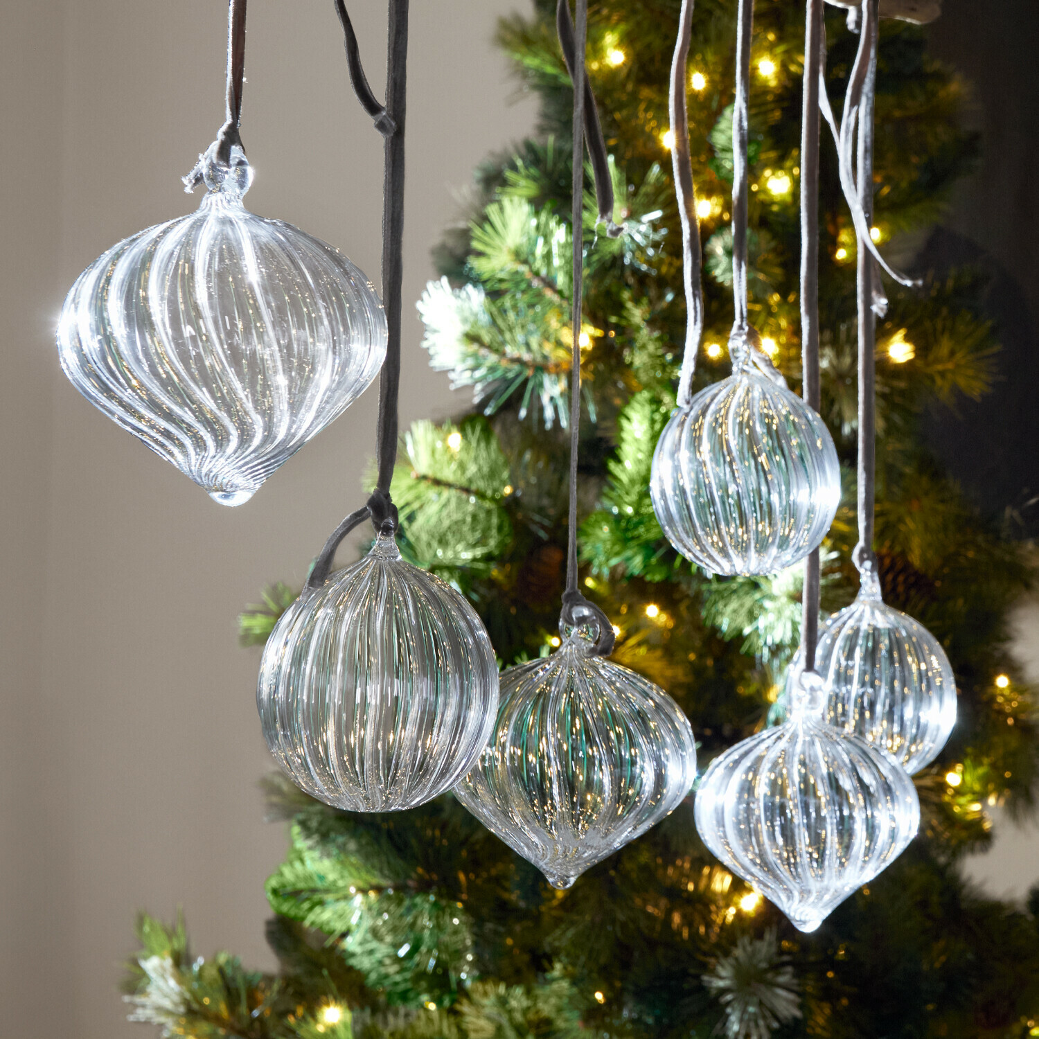 Lot de 6 boules de Noël Bavella Boules de Noël en verre transparent avec rainures suspendues devant un sapin illuminé