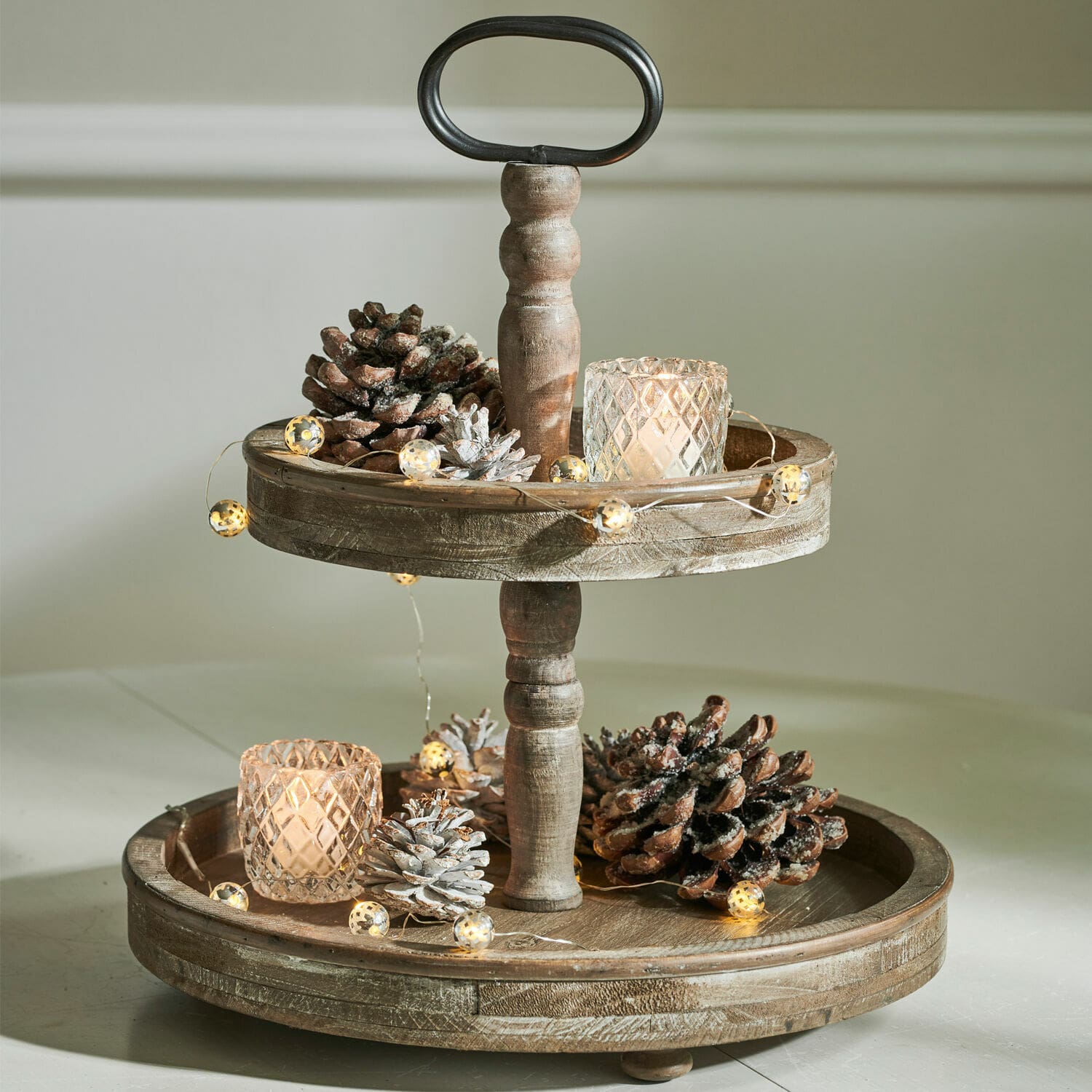 Présentoir à étages Amboise Présentoir en bois à deux niveaux décoré de pommes de pin et bougies LED pour ambiance chaleureuse