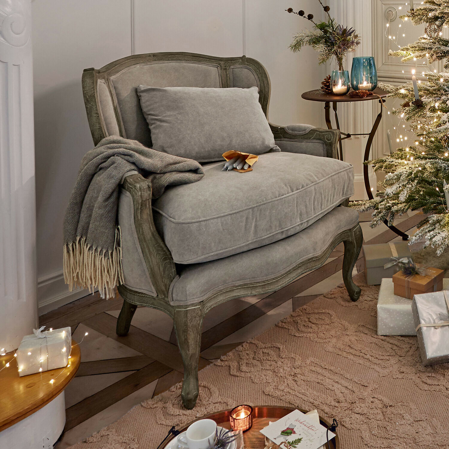 Fauteuil Kingswinford Canapé gris en tissu avec cadre en bois dans un salon décoré pour Noël avec sapin et cadeaux