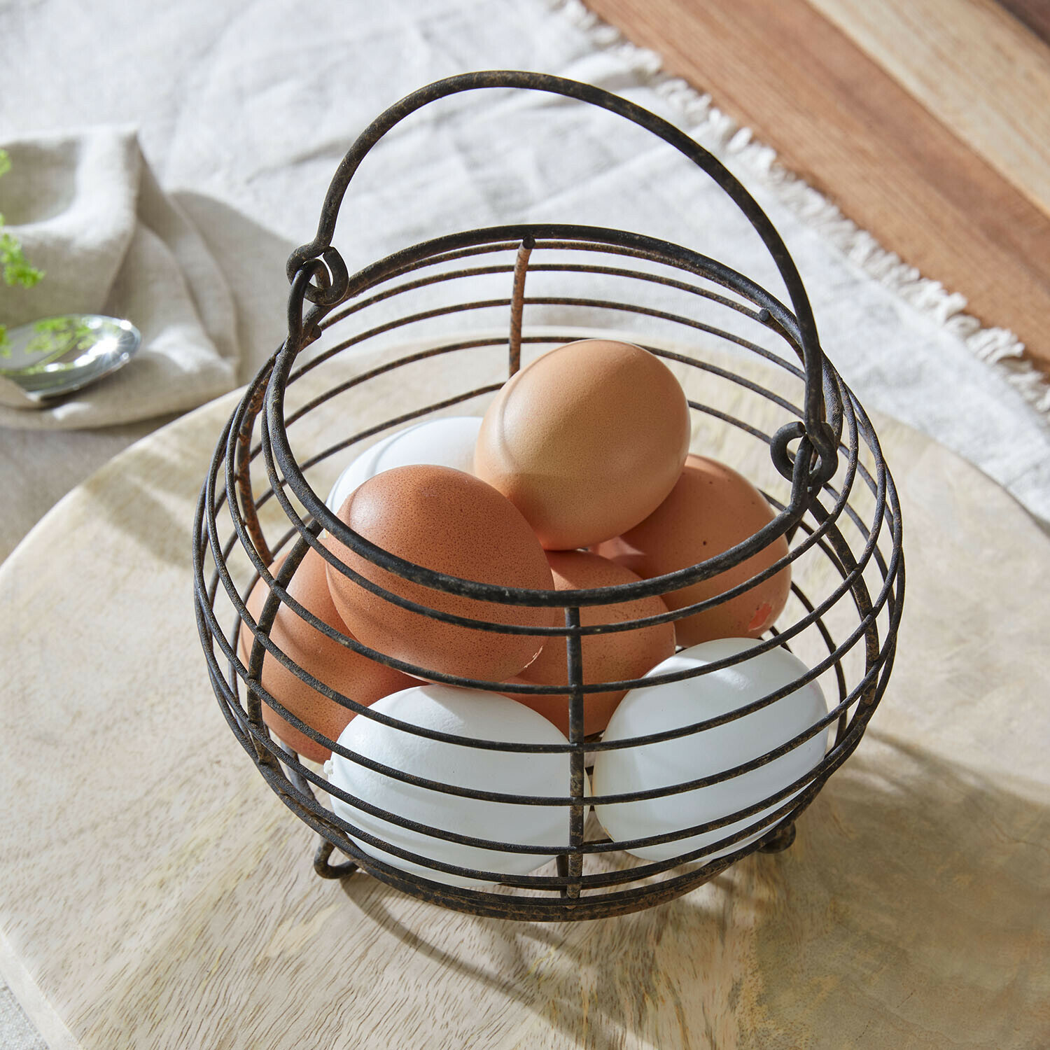 Panier Hollistone Panier métallique vintage pour œufs avec œufs bruns et blancs sur surface en bois clair
