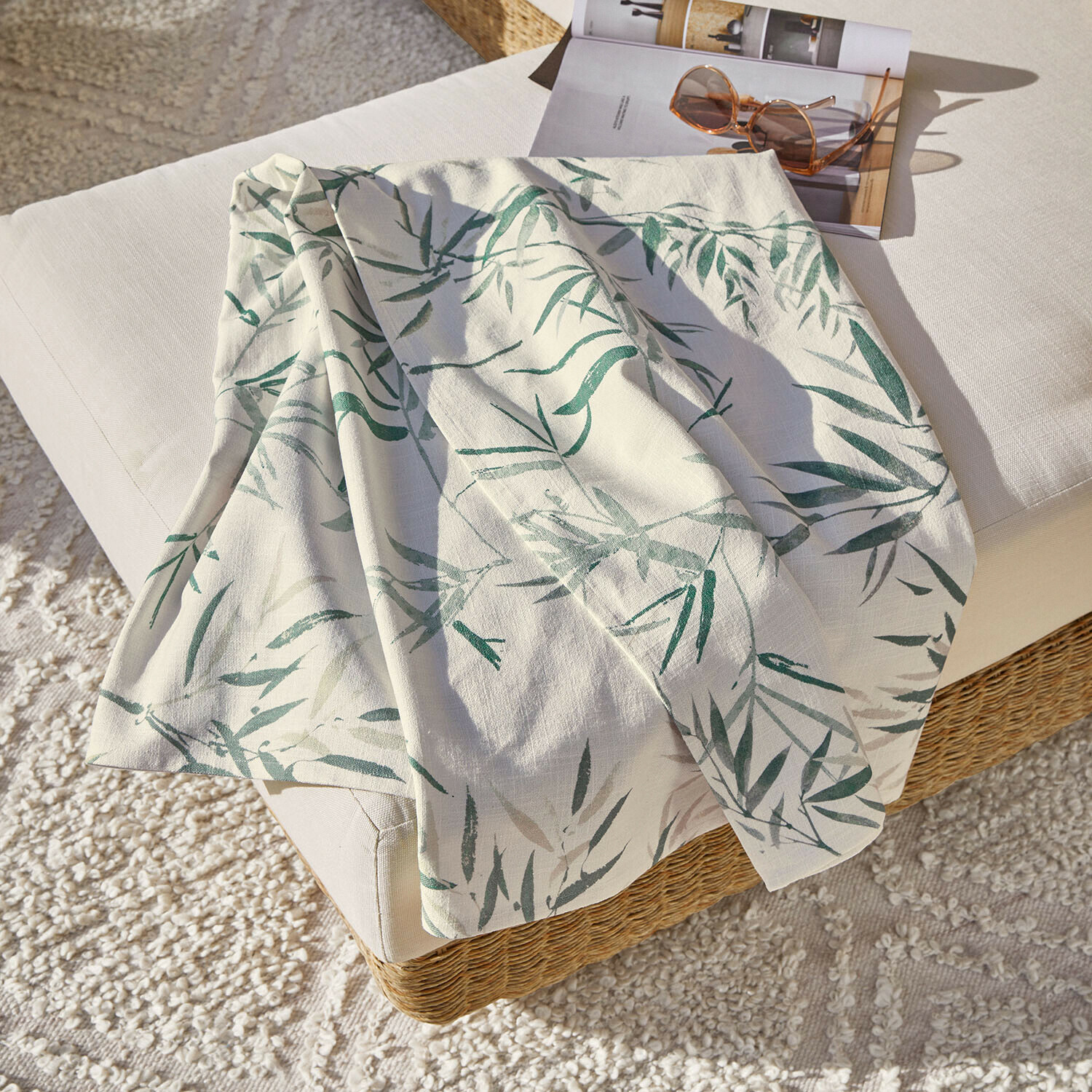 Plaid Clarisa Nappe en lin blanc avec motif de feuilles vertes sur canapé, décoration intérieure et textile maison