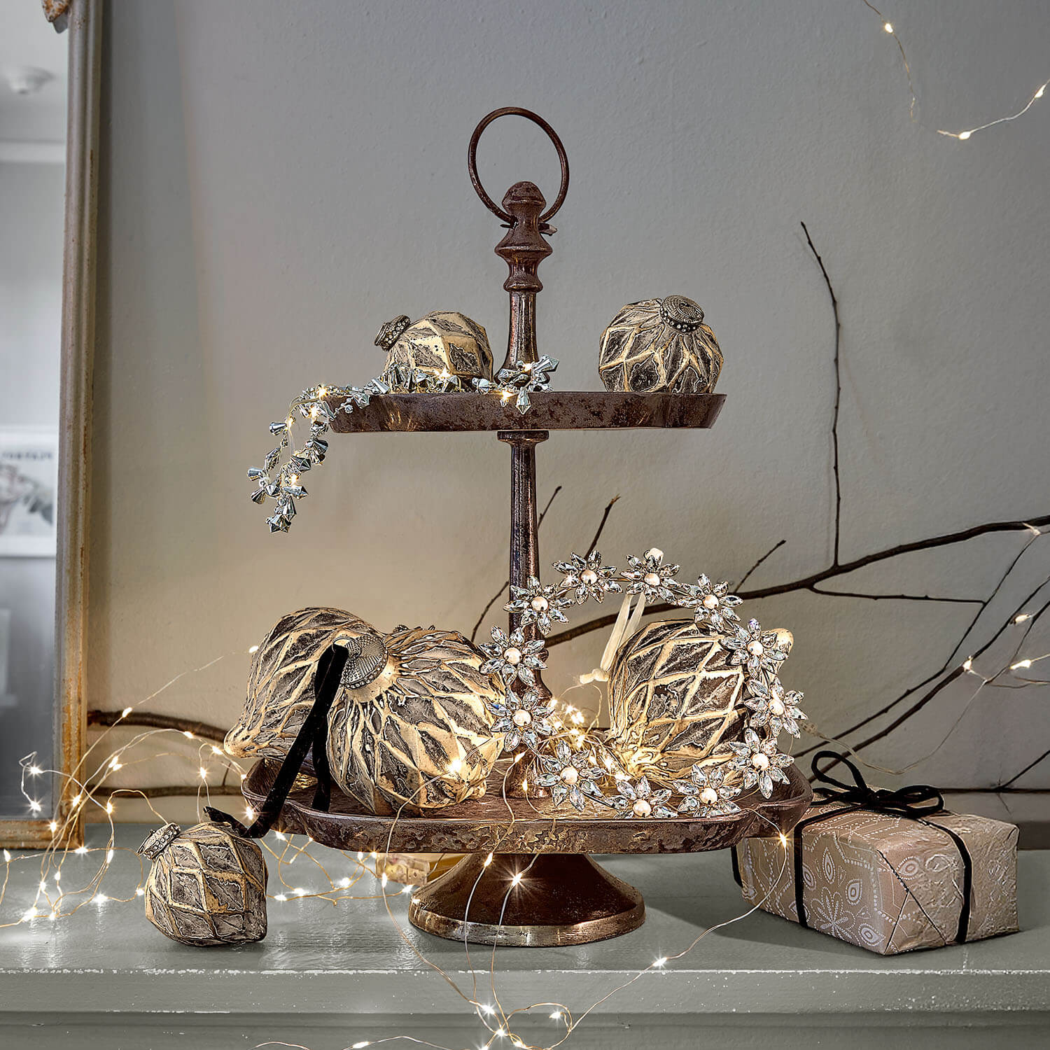 Présentoir à deux niveaux en métal avec décorations dorées et guirlandes lumineuses LED pour décoration festive