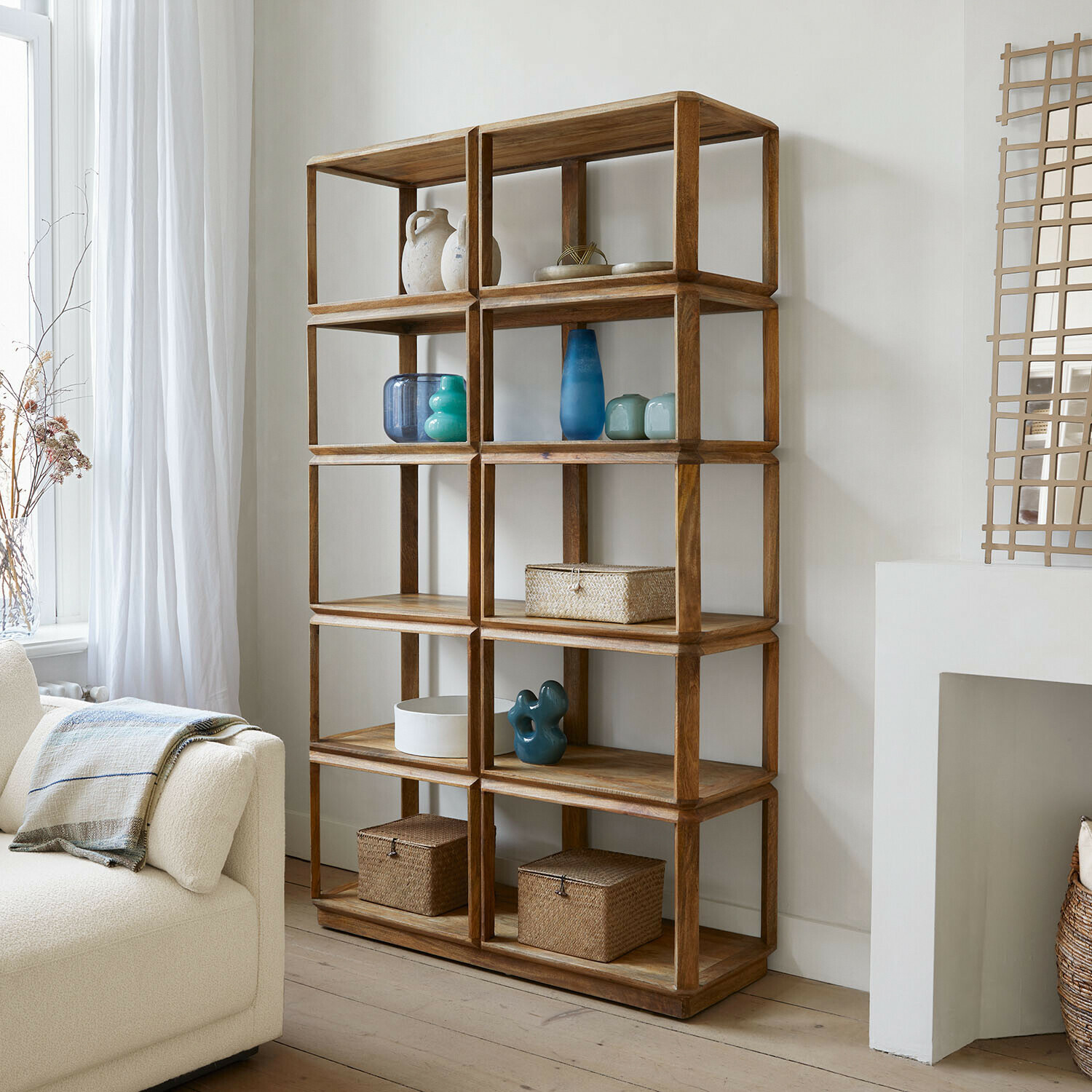 Étagère Inverly Étagère en bois naturel avec étagères ouvertes, décorations et paniers de rangement dans un salon lumineux