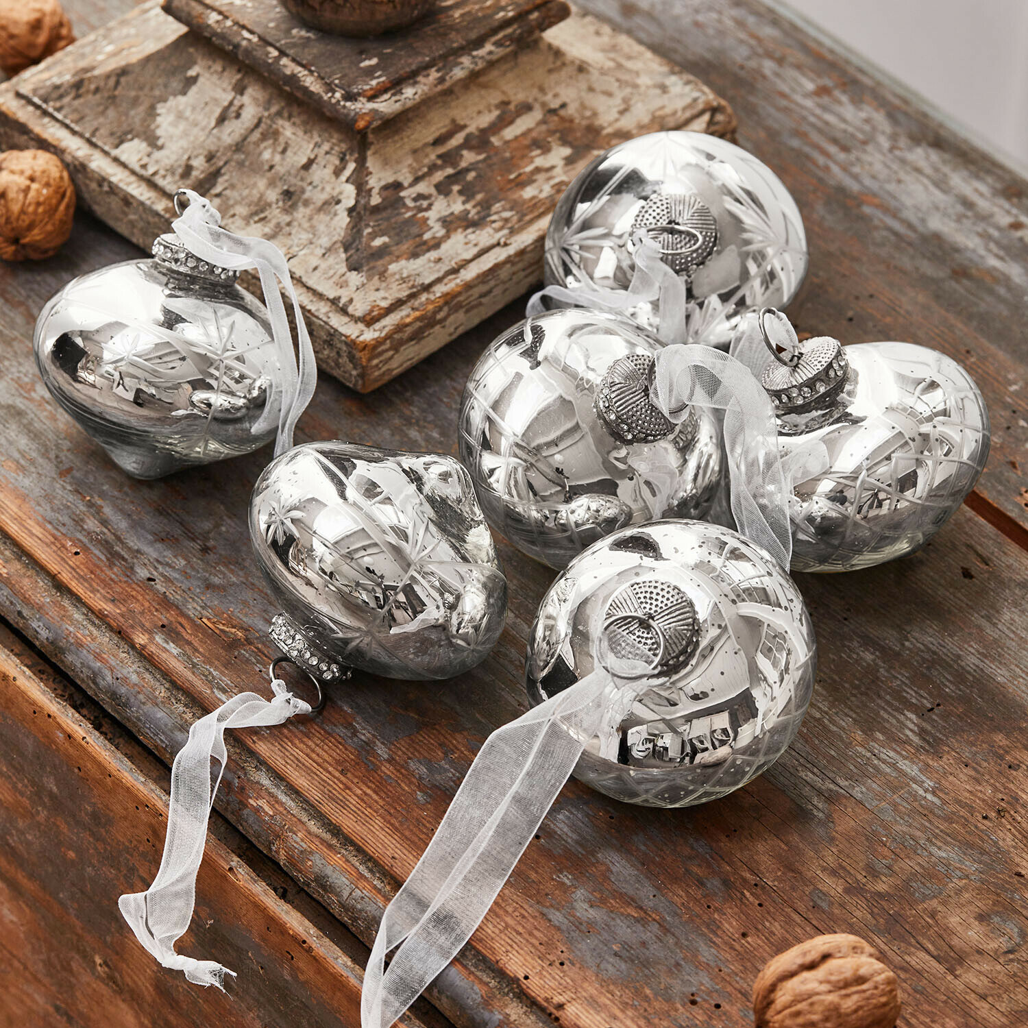 Lot de 6 décorations de Noël Cheshire Boules de Noël en verre argenté avec ruban blanc posées sur une table en bois, décoration festive
