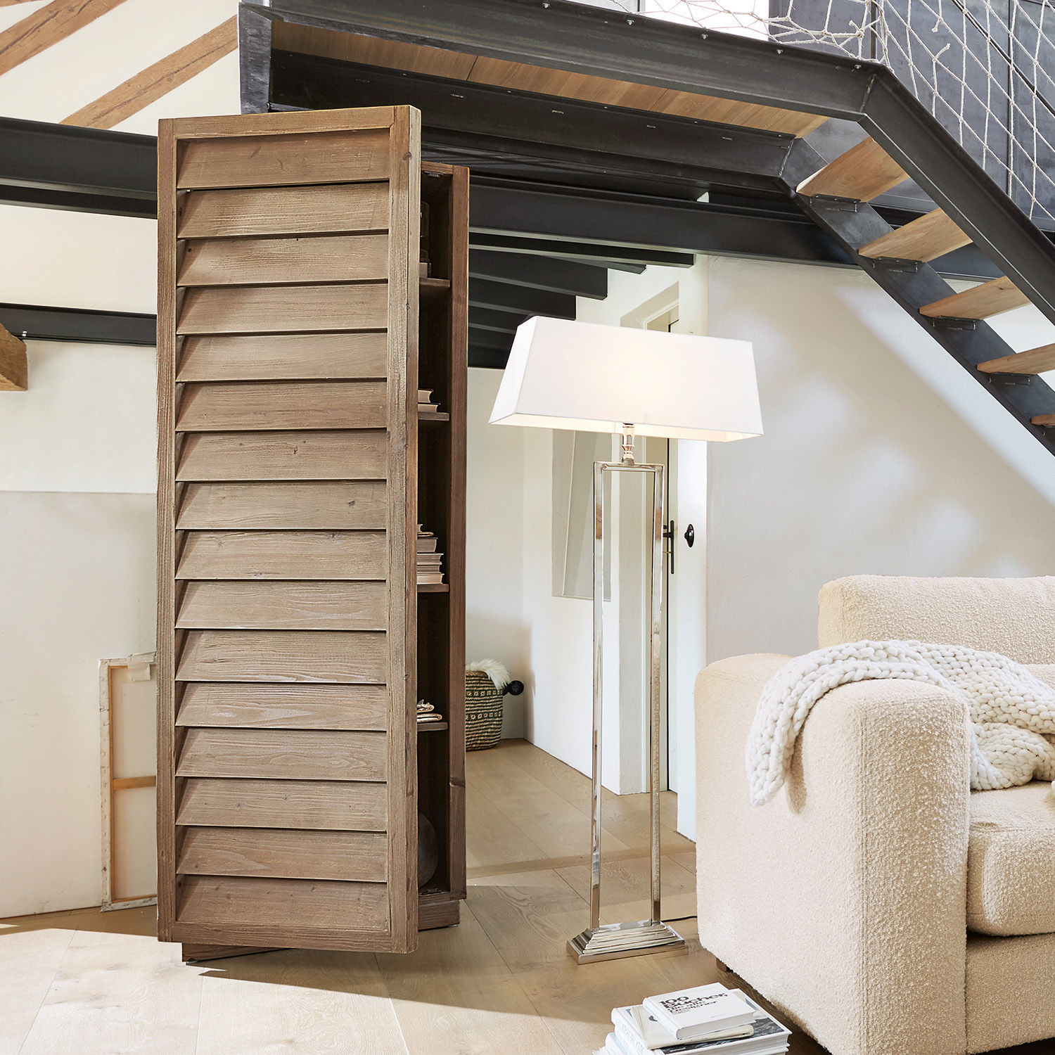 Armoire Bordó Armoire en bois avec portes à persiennes couleur naturelle dans un salon moderne avec lampe et canapé