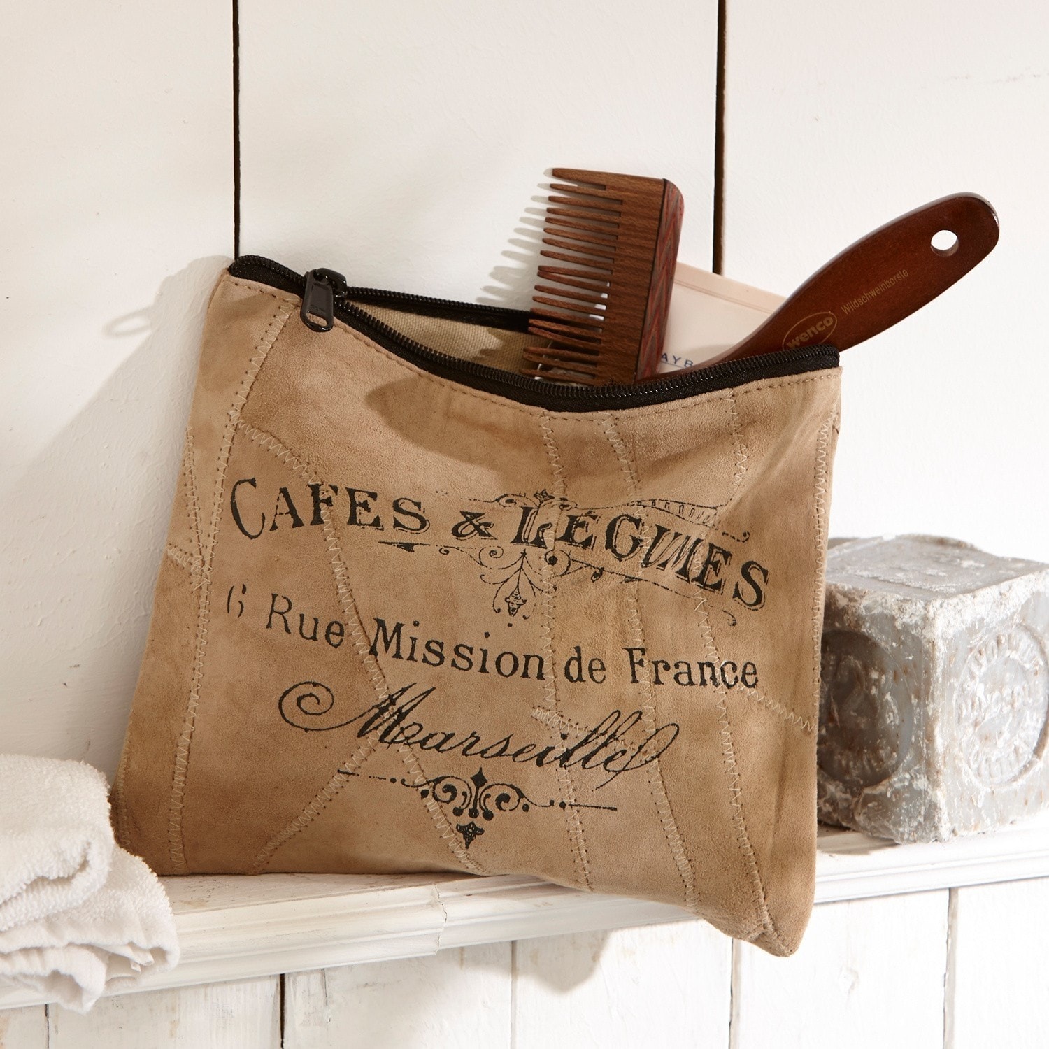 Pochette Jeannice Trousse beige en daim avec fermeture éclair noire et impression française, peigne en bois visible sur étagère