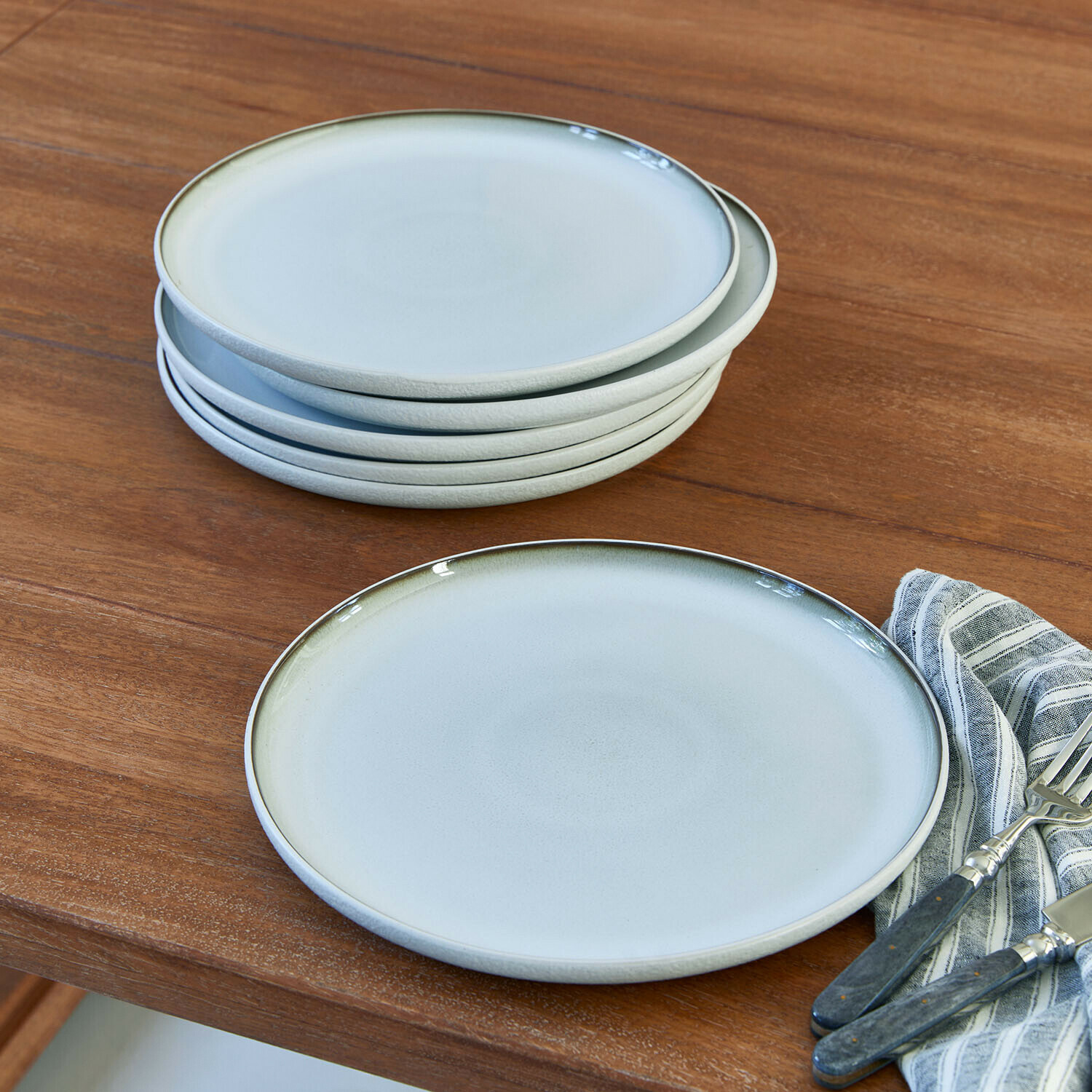 Lot de 6 assiettes Eiruna Ensemble d'assiettes en céramique gris clair avec bord vert pâle sur table en bois avec couverts