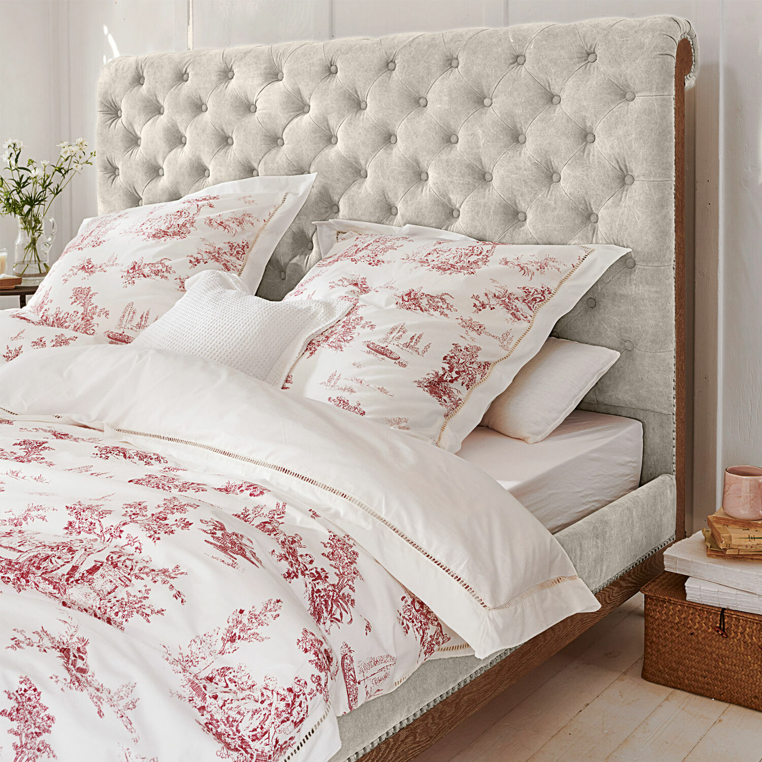 Parure de lit Toile rouge Lit avec tête de lit capitonnée gris clair et cadre en bois dans une chambre chaleureuse