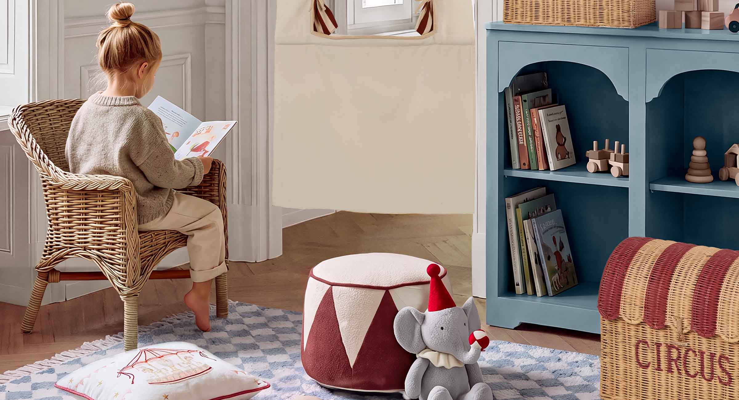 Coin enfant chaleureux avec fauteuil en osier, étagère bleue et peluche éléphant style cirque