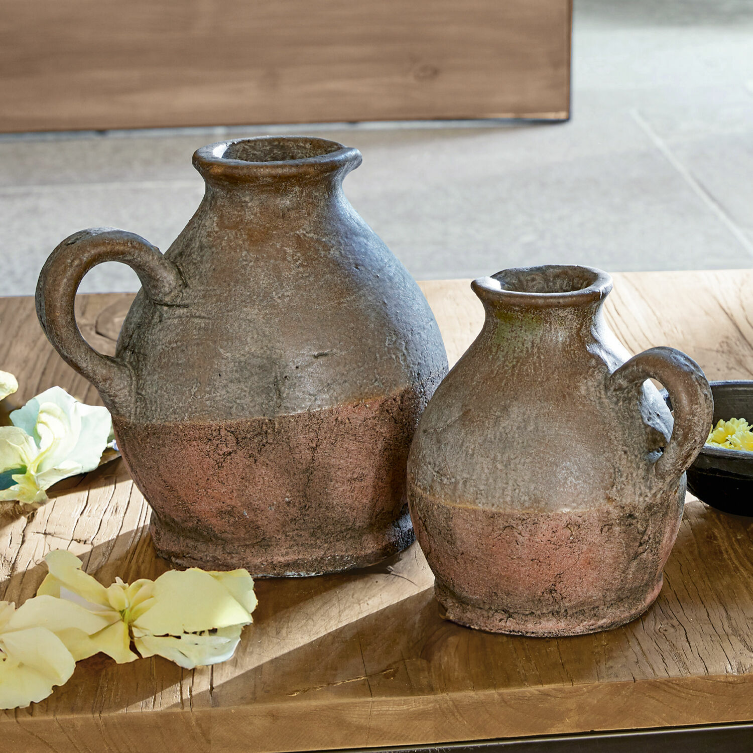 Lot de 2 vases Henriette Deux pichets rustiques en céramique brun rouille posés sur une table en bois avec des fleurs