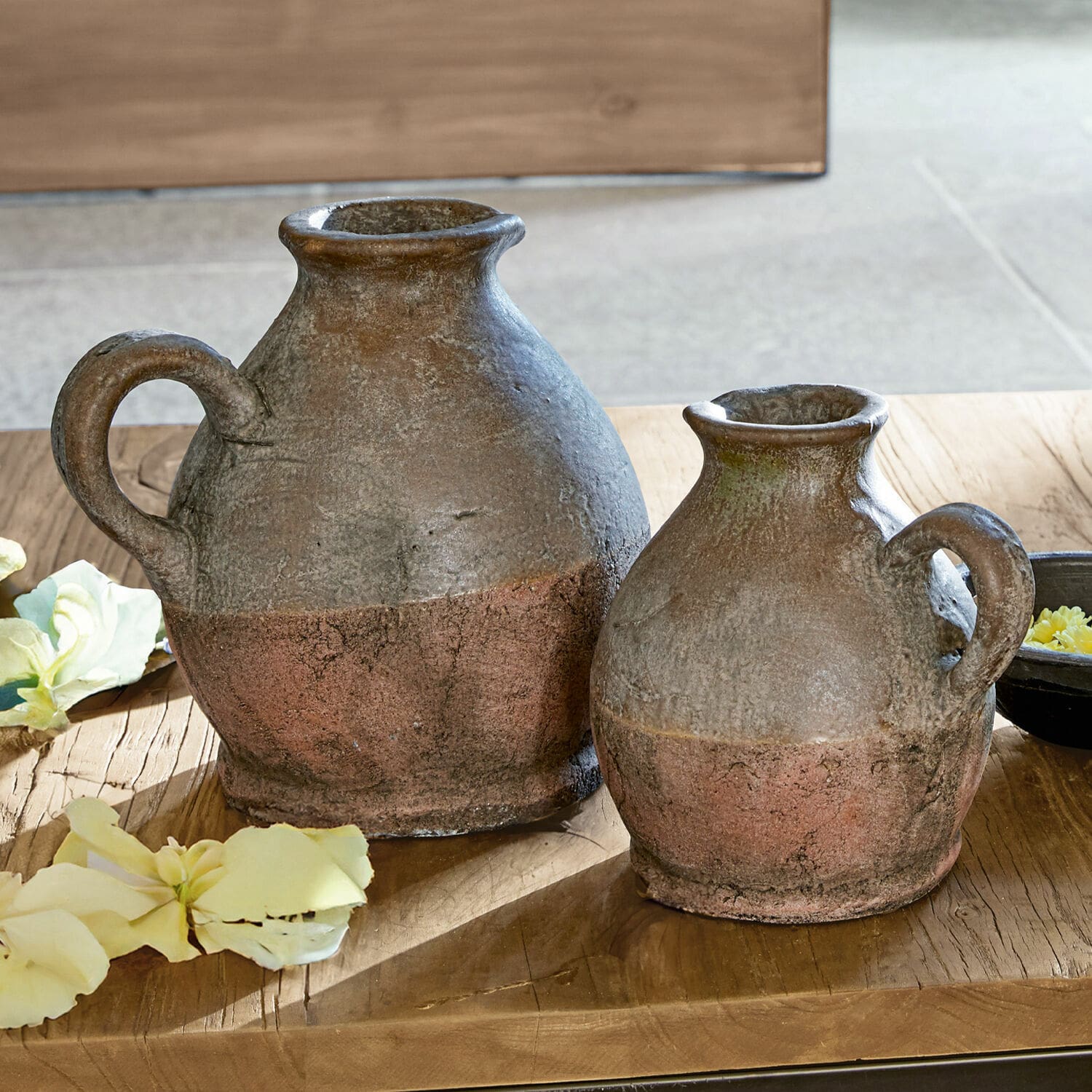 Lot de 2 vases Henriette Deux pichets rustiques en céramique brun rouille posés sur une table en bois avec des fleurs