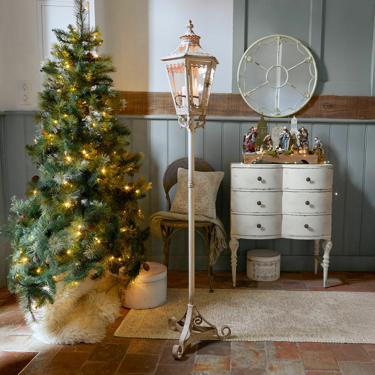 Lanterne Lumière Élysée Lanterne sur pied en métal blanc avec décorations vintage dans un intérieur rustique avec sapin