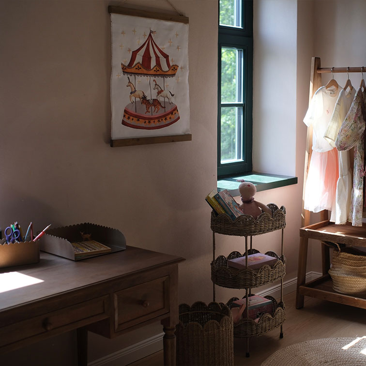 Chambre d'enfant chaleureuse avec bureau en bois, étagère en osier et décoration murale carrousel