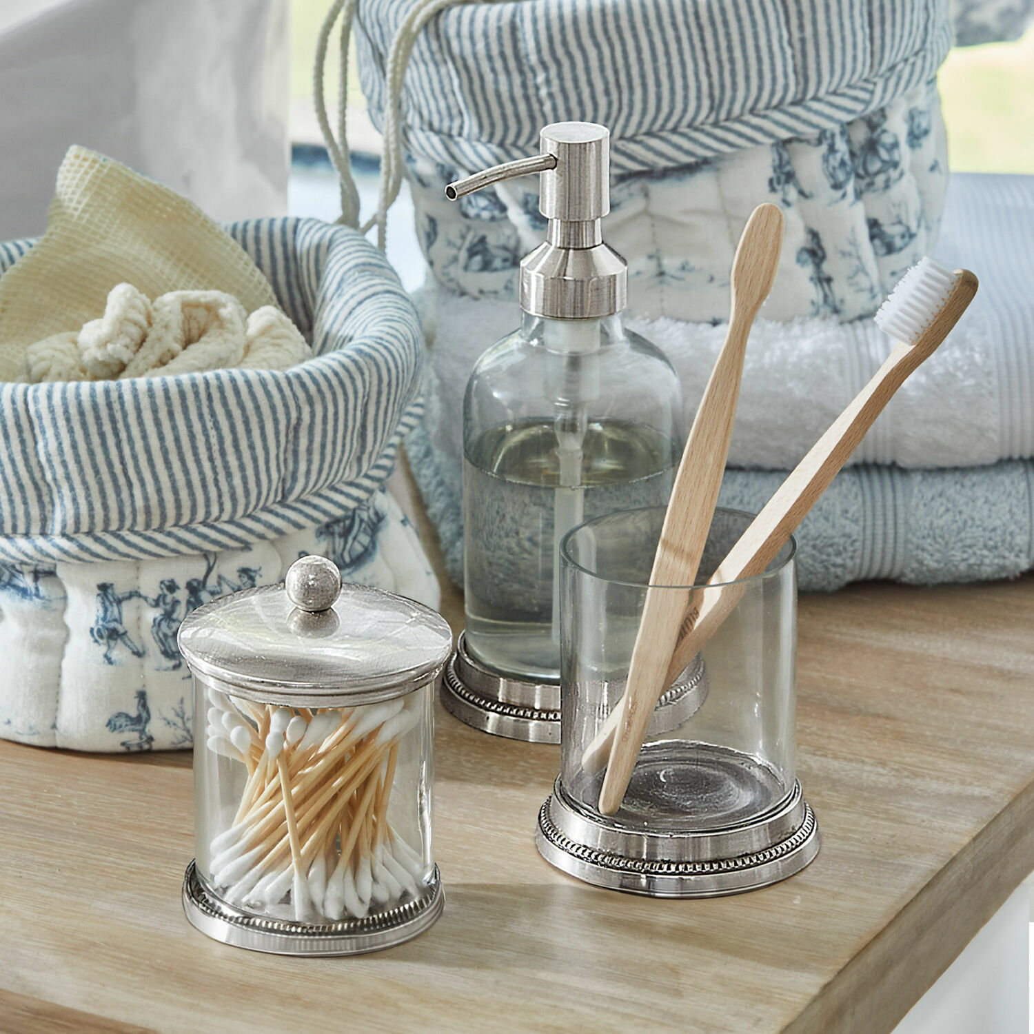 Set de salle de bains Drinapoly Pots en verre avec coton-tiges et brosses à dents en bambou sur un comptoir en bois dans une salle de bain