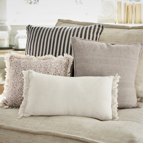 Ensemble de coussins décoratifs beige et marron sur canapé beige, tissus doux, décoration intérieure salon