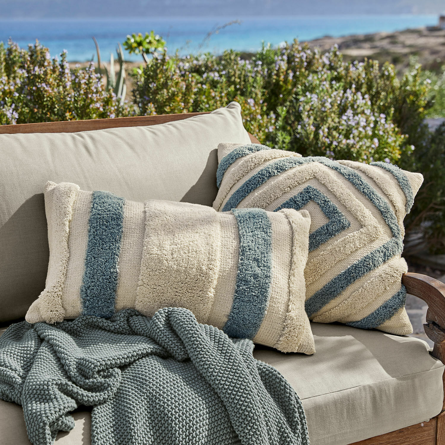 Lot de 2 housses de coussins Melyn Coussins décoratifs beige et bleu en tissu doux sur canapé beige avec couverture tricotée