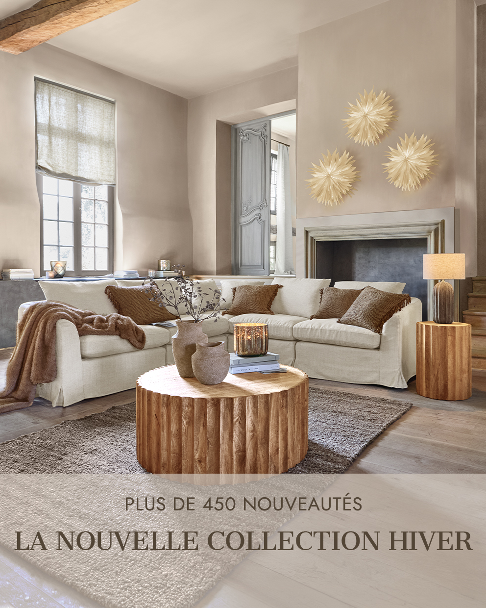 Salon chaleureux avec canapé beige, table basse en bois et décorations murales pour la nouvelle collection hiver