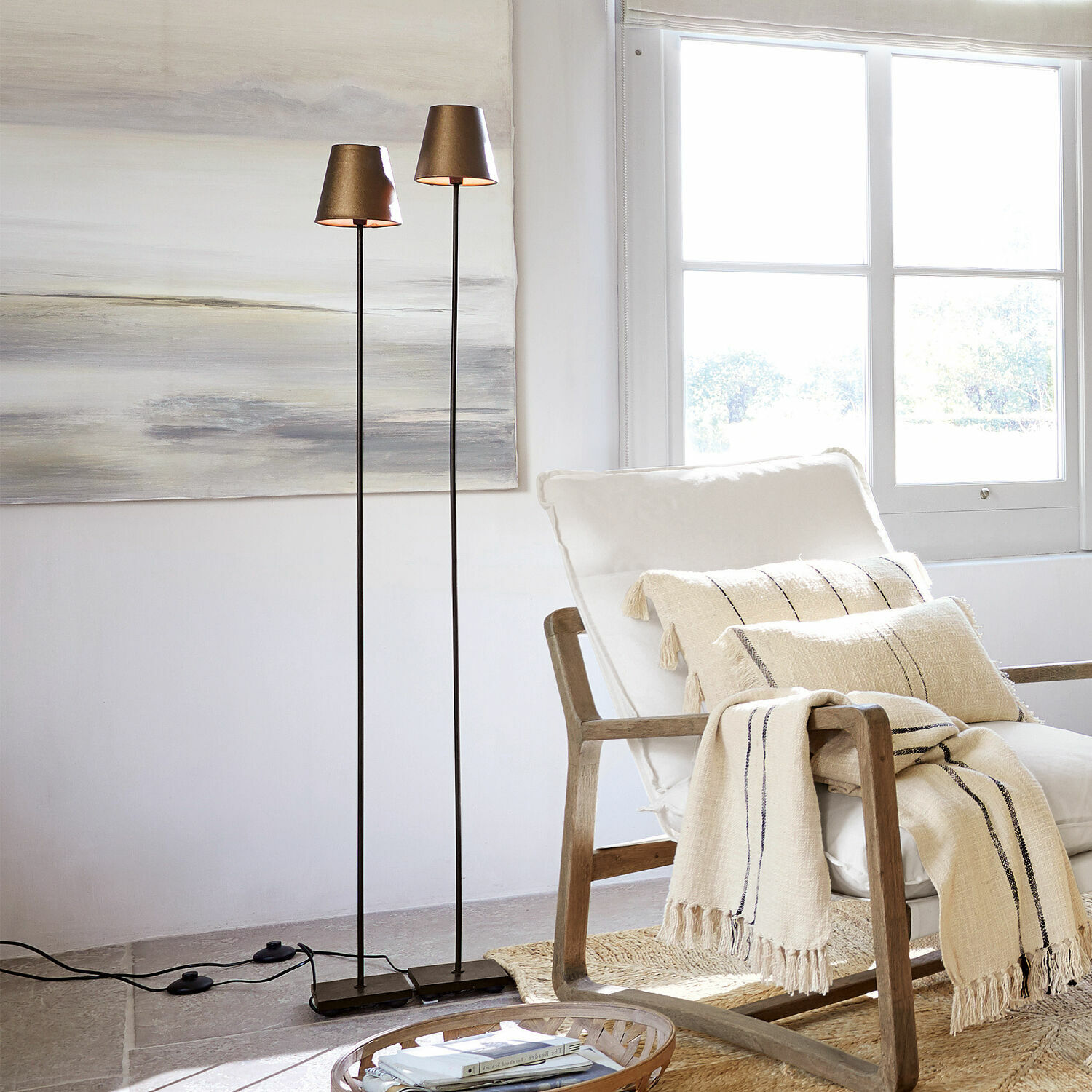 Lot de 2 lampadaires Tacoma Deux lampadaires fins avec abat-jours métalliques dorés dans un salon lumineux et moderne